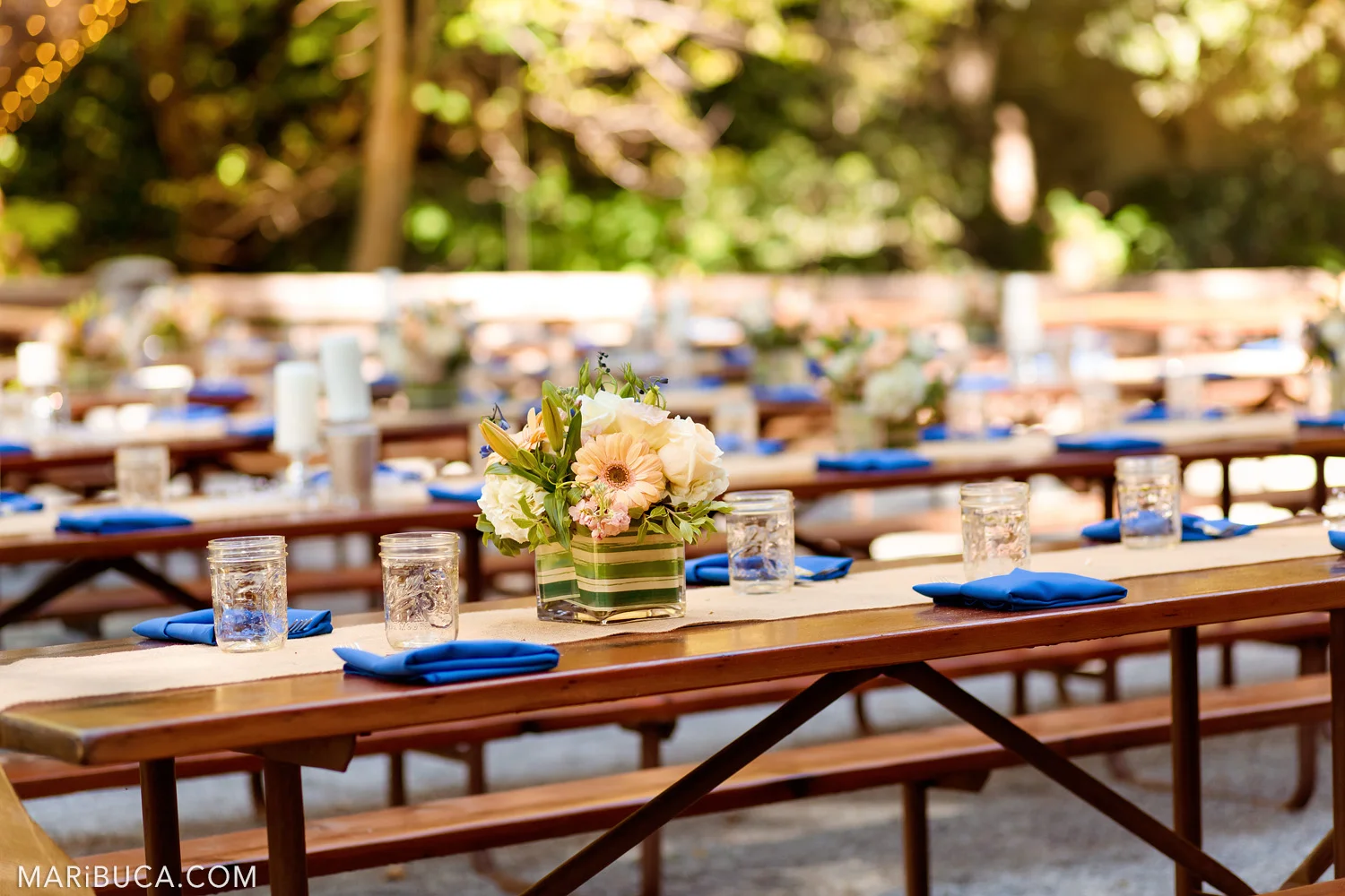 Wedding tables decoration: flowers in the vases, navy blue napkins, and glasses of water in the Saratoga Springs Venue