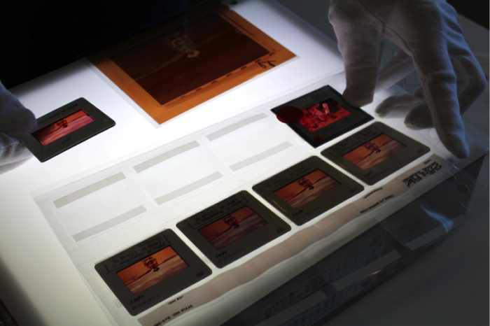 Original slides featuring John Wayne on the set of The Searchers (1956) are viewed using a lightbox. Photo courtesy of John Wayne Enterprises