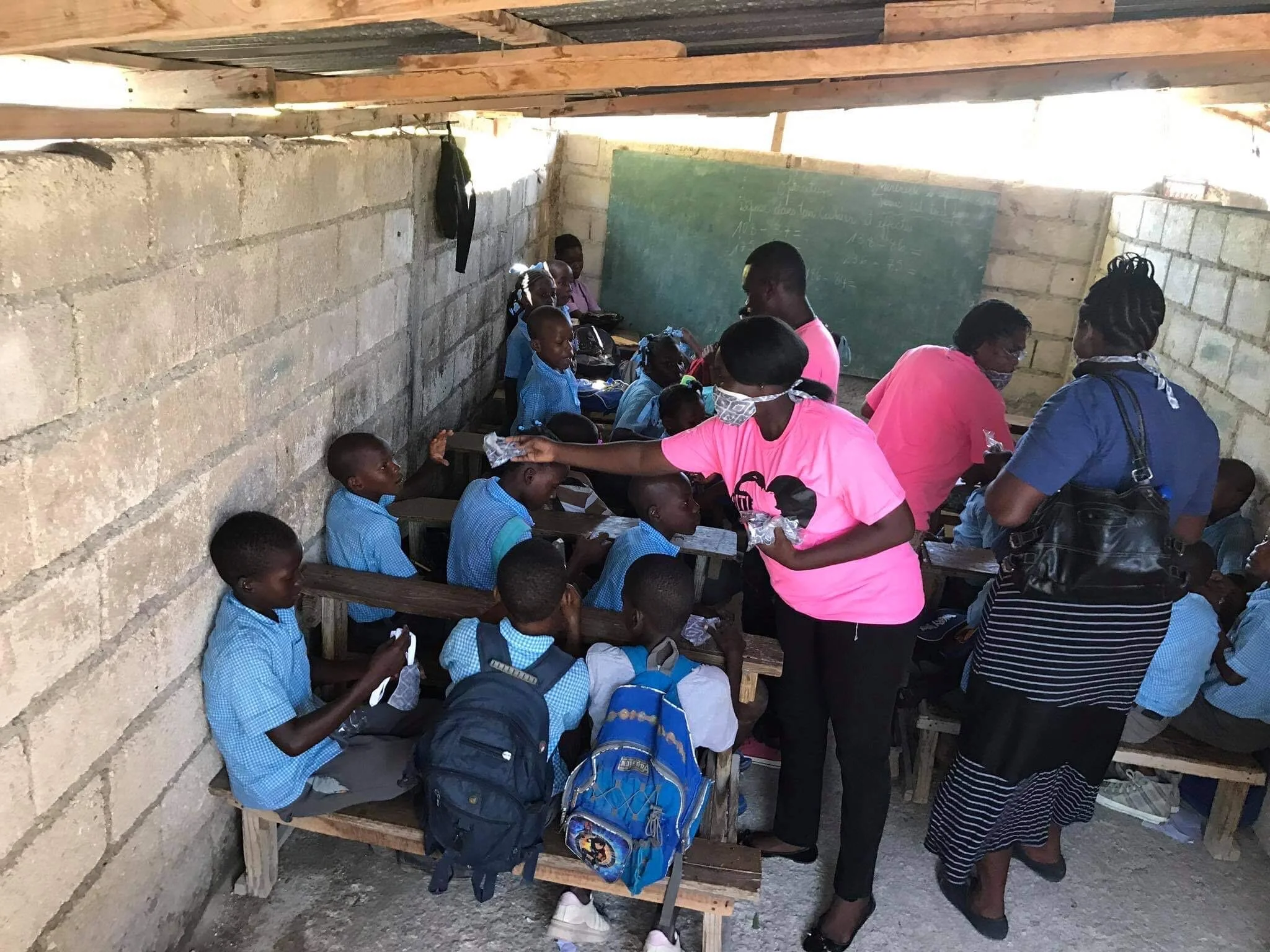  Hope Sewn ladies handing out masks to school children 