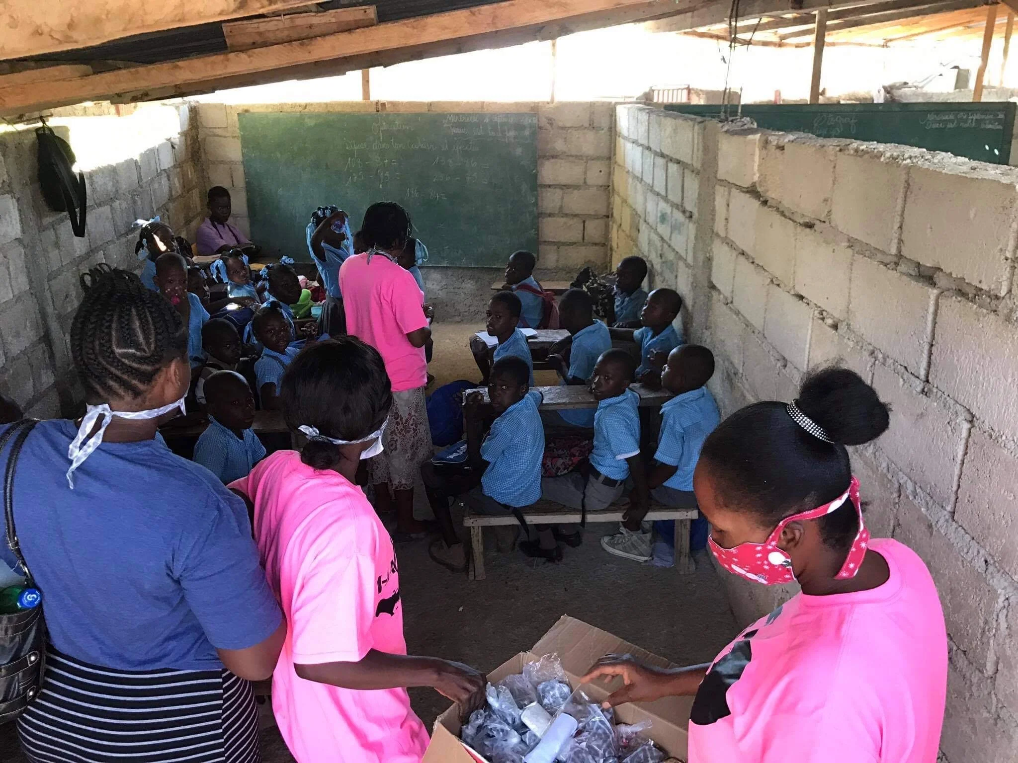  Hope Sewn ladies handing out masks to school children 