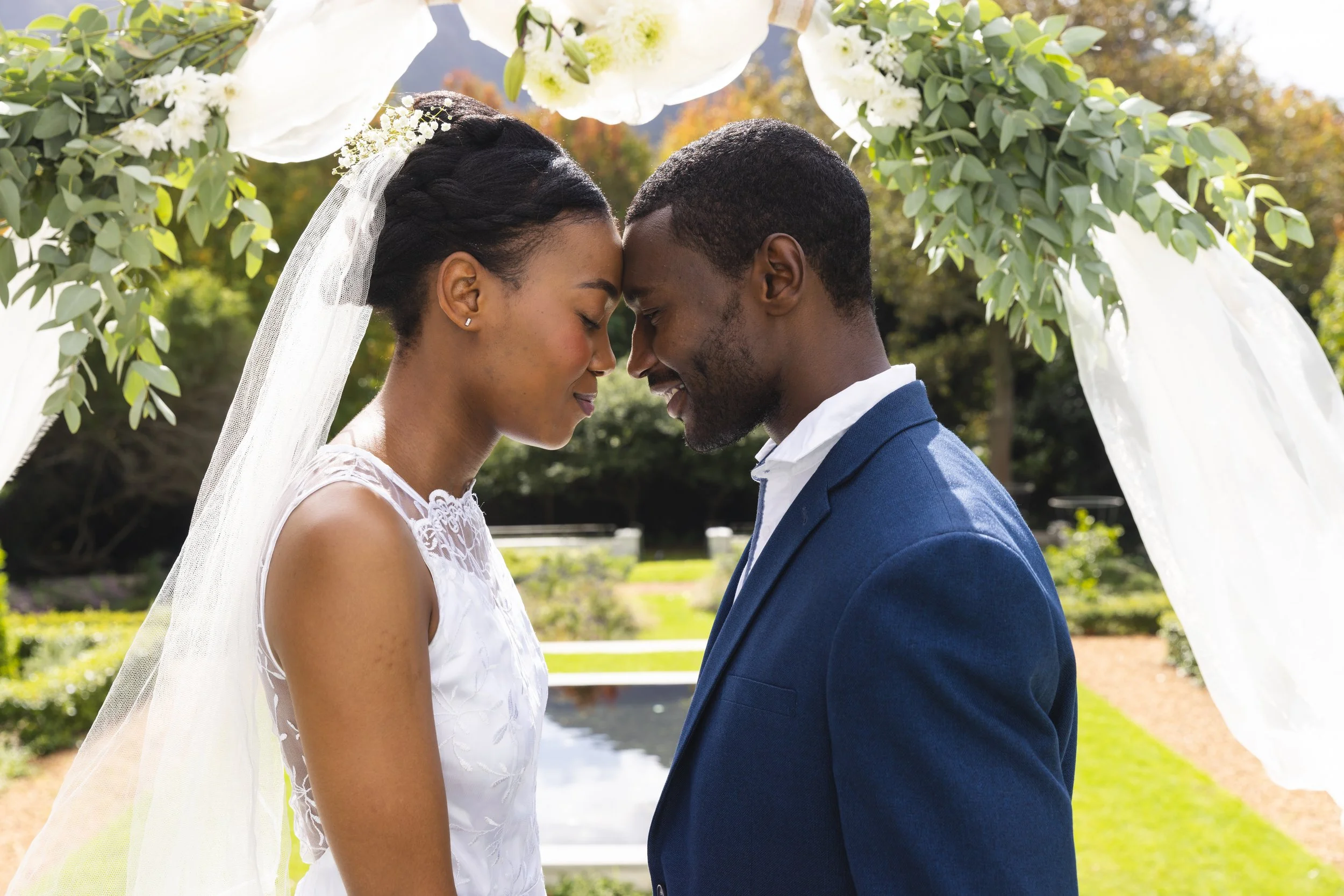 happy-african-american-bride-groom-touching-heads-wedding-arch-ceremony-sunny-garden.jpg