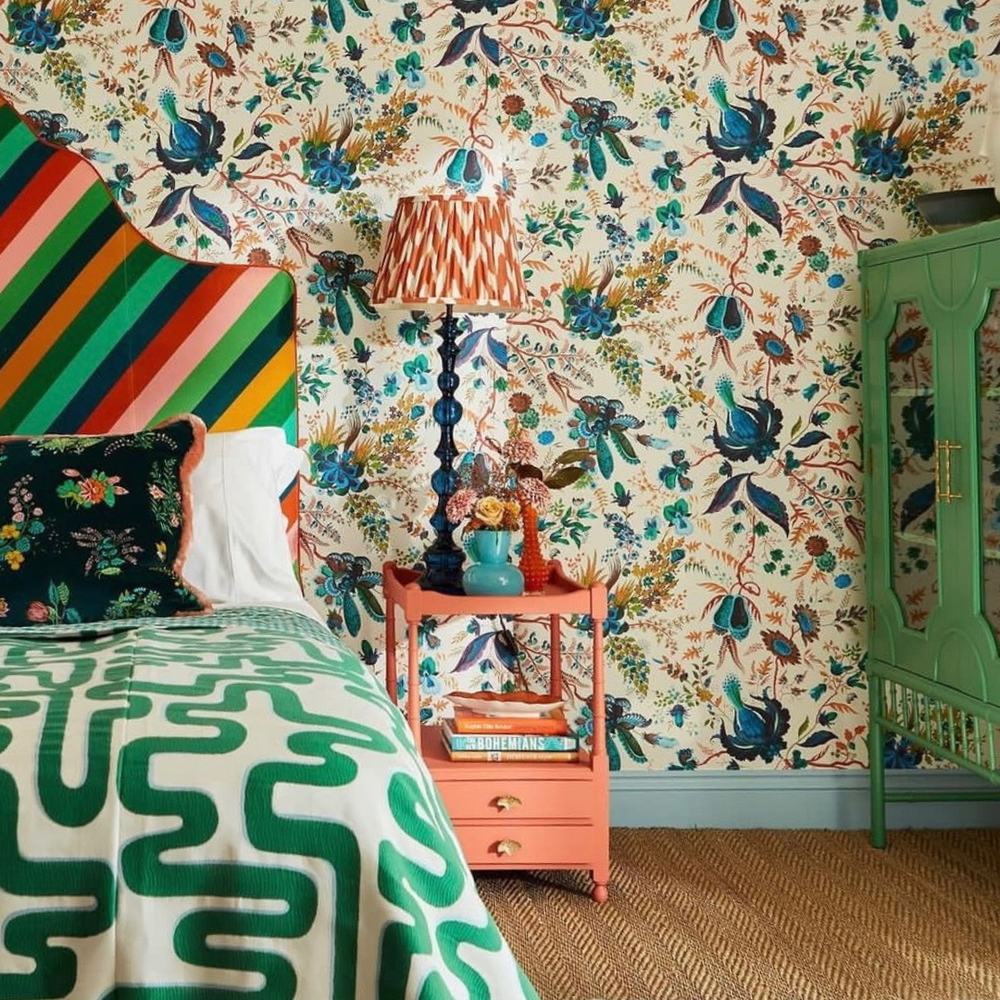 Bright geometric style headboard, on master bed, with floral wallpaper