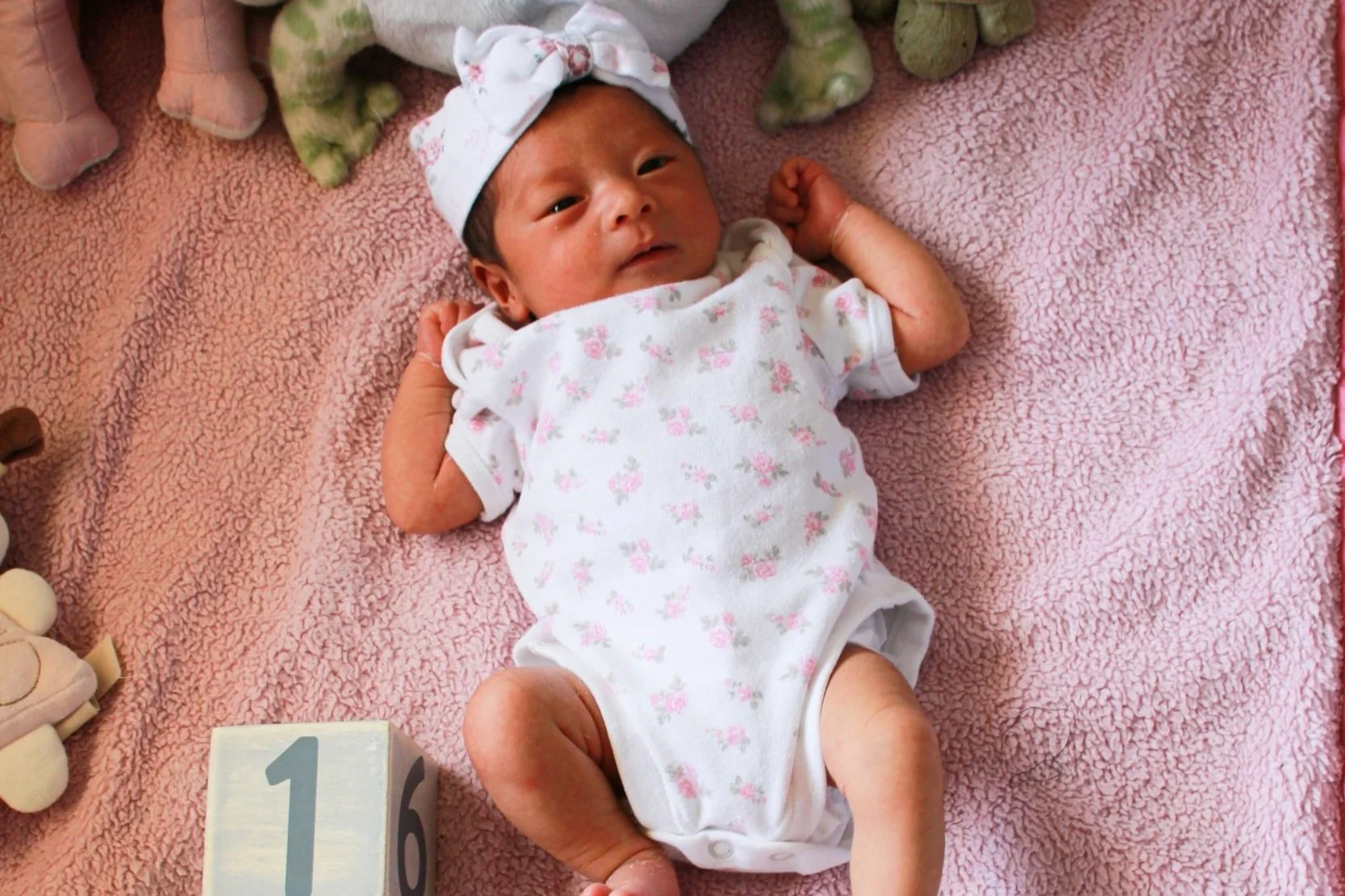 A one week old baby on a blanket. Robbins Doula Services is a postpartum doula in Missouri that helps with baby care, sleep, and breastfeeding.