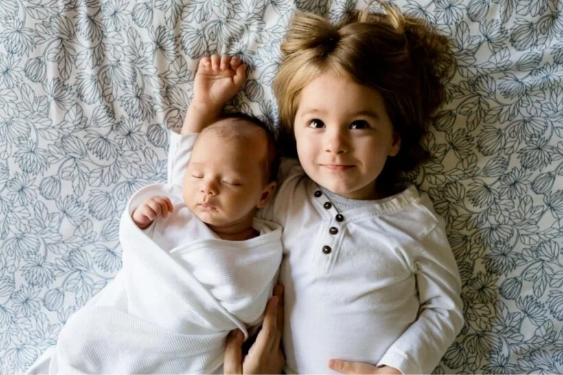 A baby and older sister. A St. Louis doula can help with sibling adjustment when a new baby arrives.