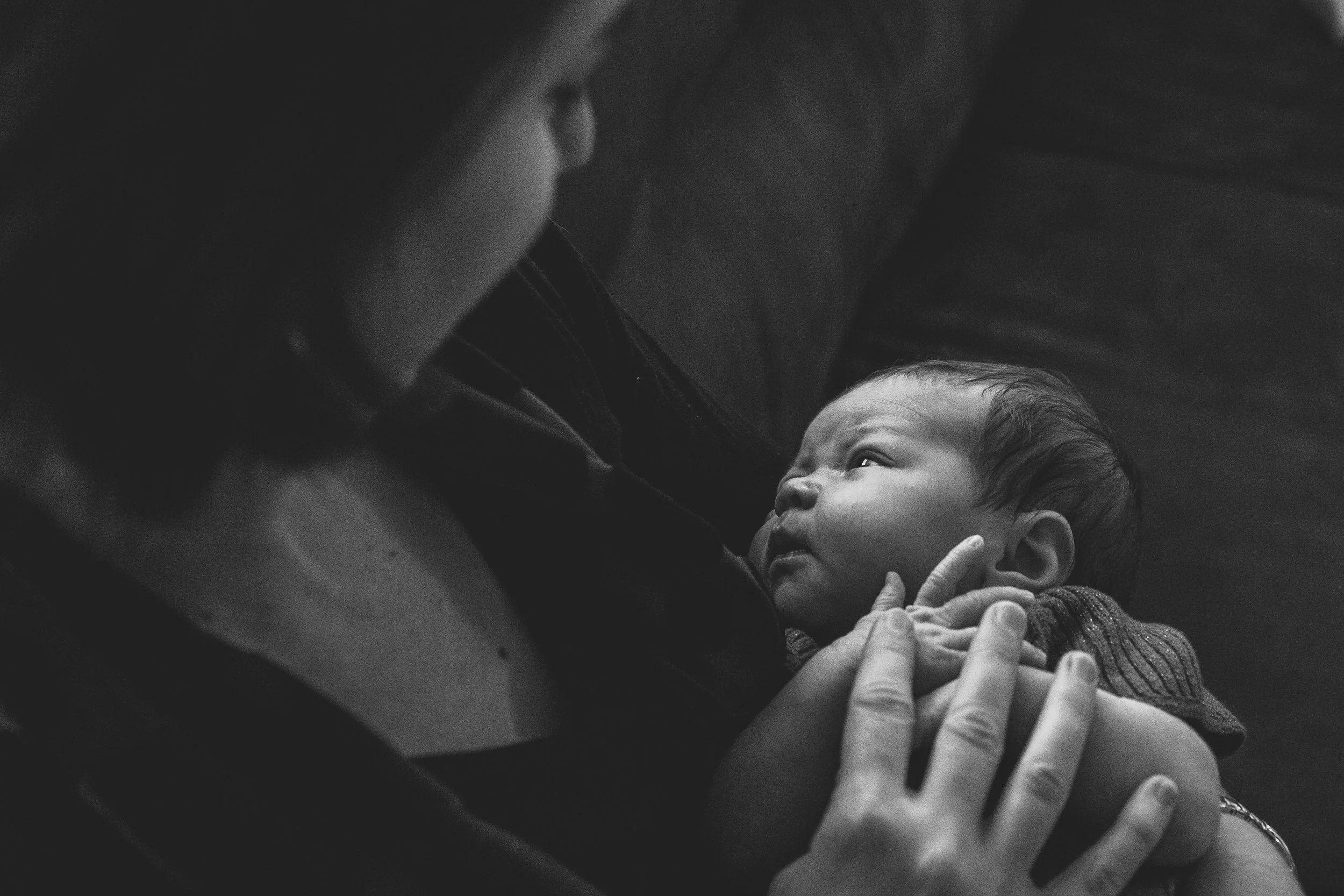 A St. Louis postpartum doula holding a baby. Robbins Doula Services provides postpartum doula support in person and virtually.