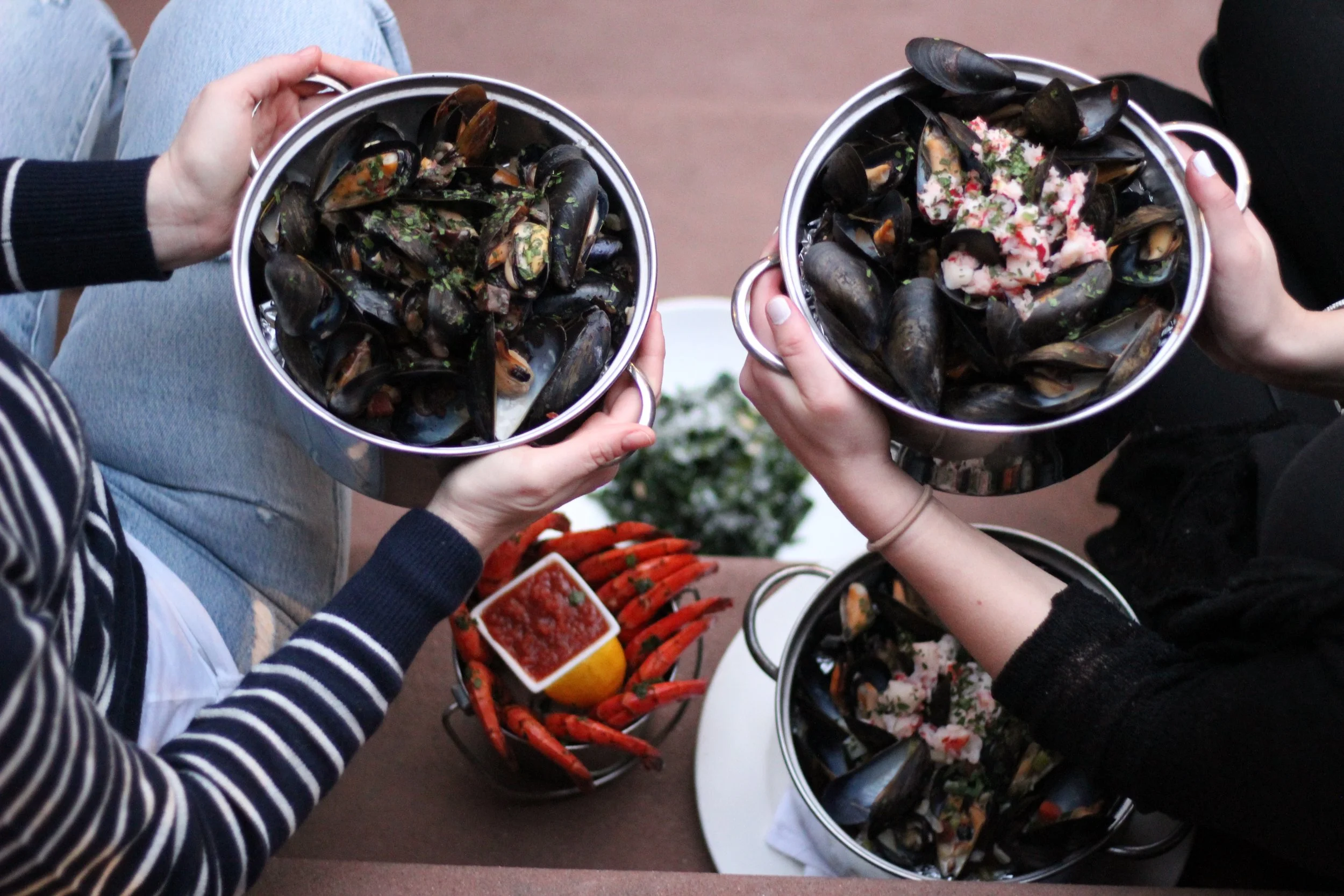 Two bowls full of Mussels and crab legs