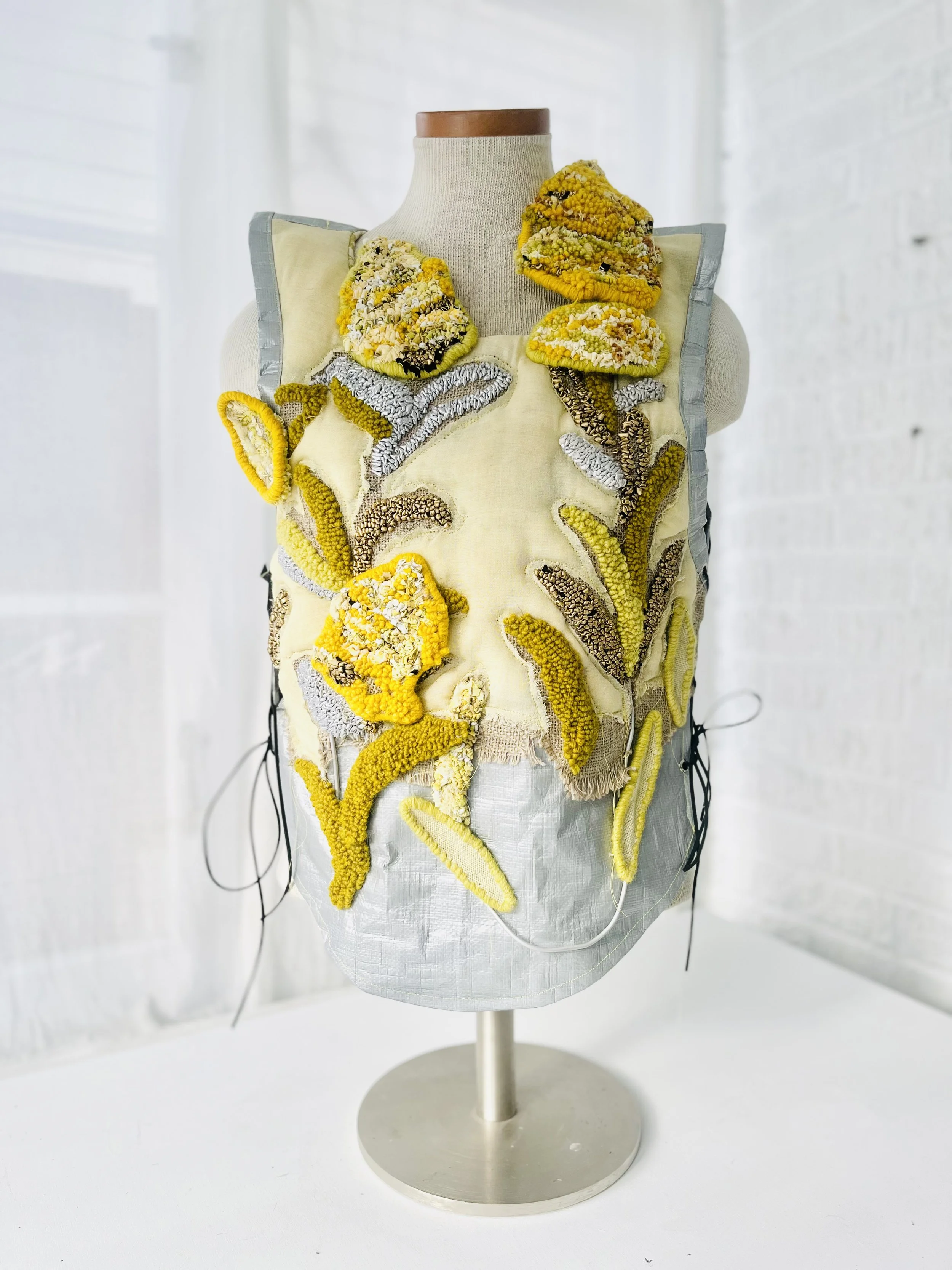 Goldenrod Vest, 2025, camping tarpaulin fabric, yarn, re-purposed textiles, metallic sheen textiles. Techniques: Hand hooked, hand carded wool hand dyed with goldenrod, machine and hand sewn.