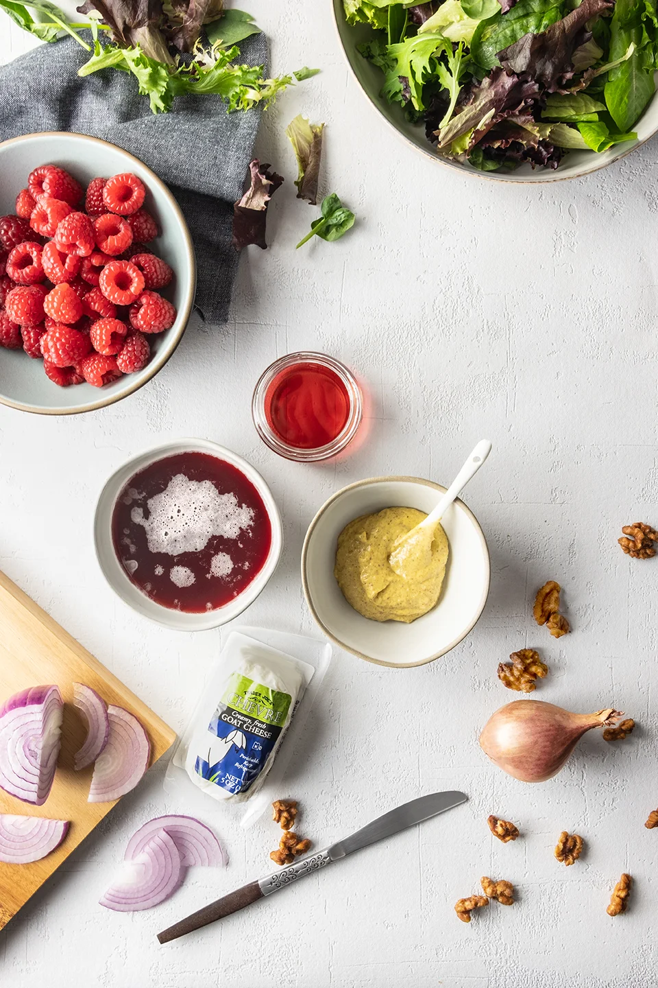  Raspberries, lettuce, lambic dressing in bowls on a white background.  