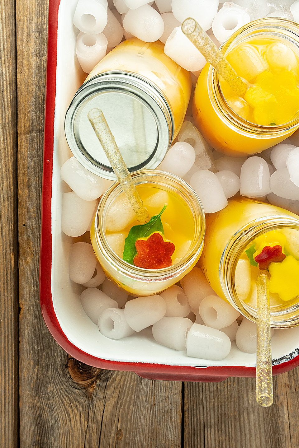  Mango and basil fizz mocktail in a white enamel container ready for a picnic.   