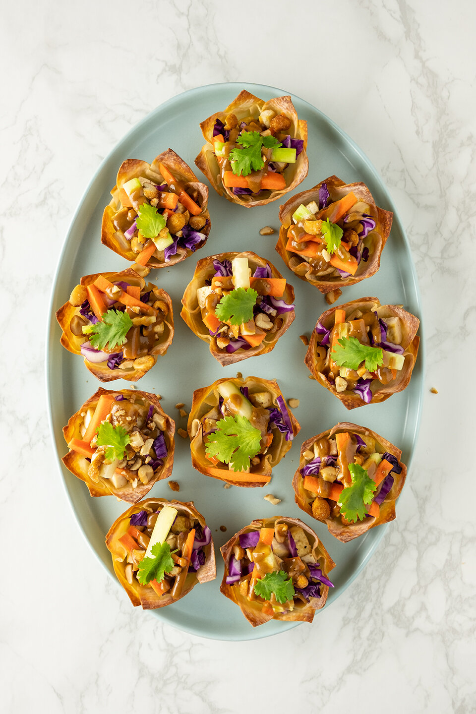  Thai tofu cups with peanut sauce on a light blur platter. Ready to be served to guest.  