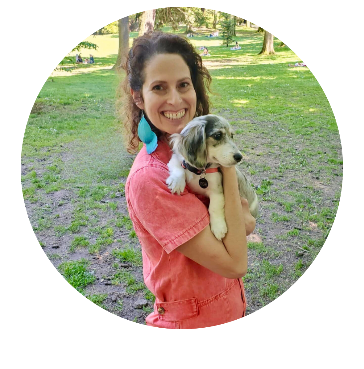 Cindy holding a dog in a lovely green park