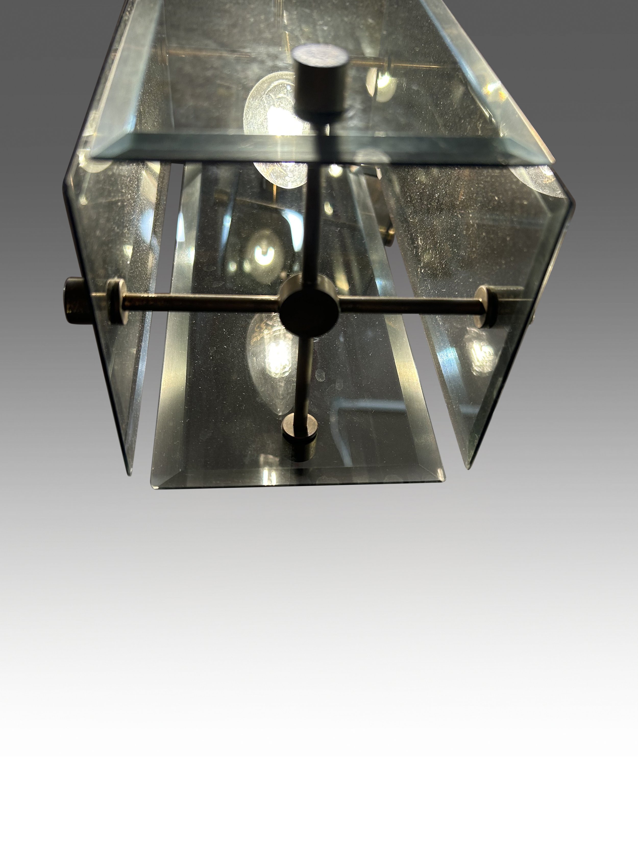 Elegant 1970s Italian chandelier by Fontana Arte, featuring a brass frame with six descending light points and beveled smoked glass shades. Inspired by Max Ingrand’s designs