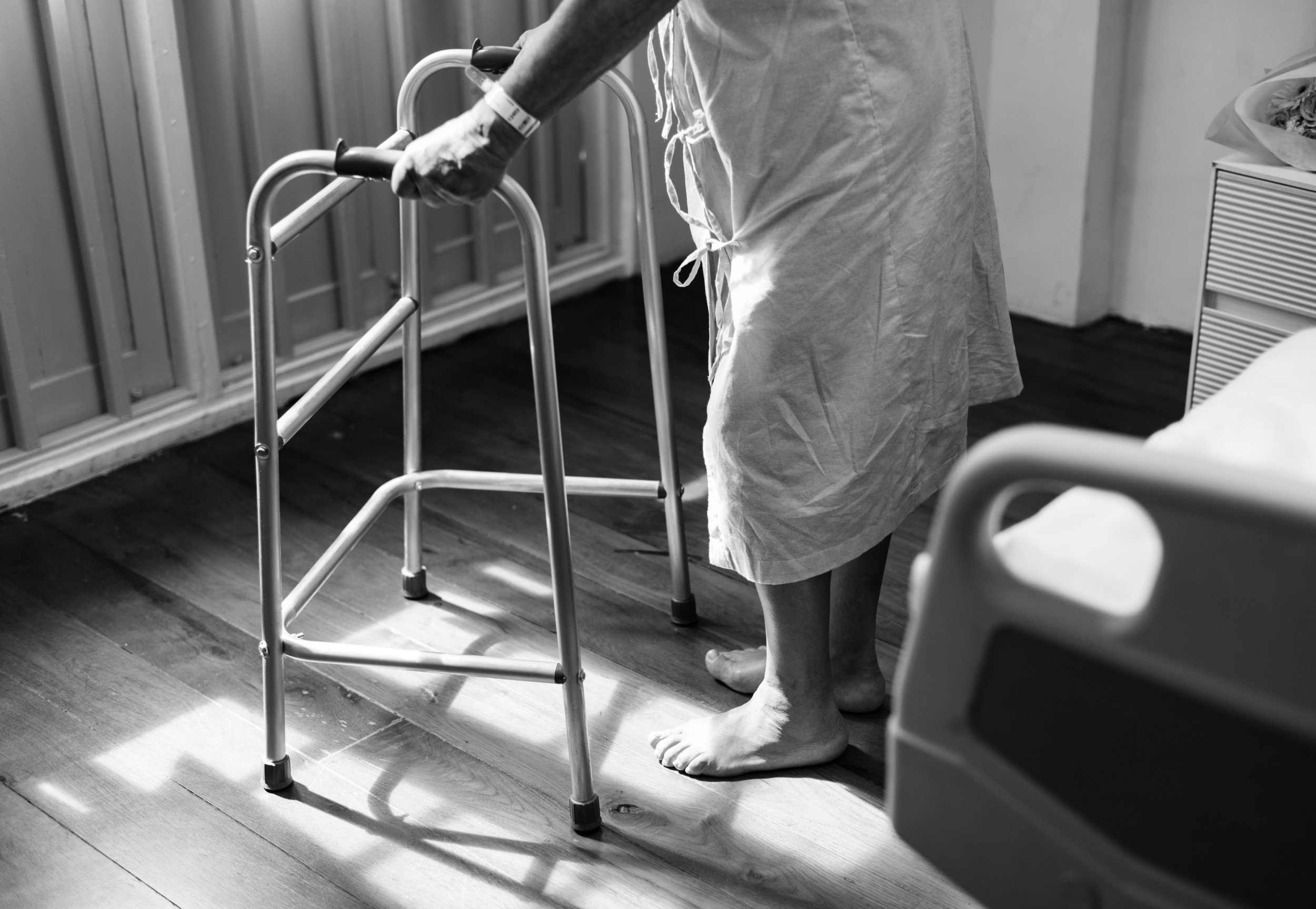 An elderly patient getting out of bed with a walker