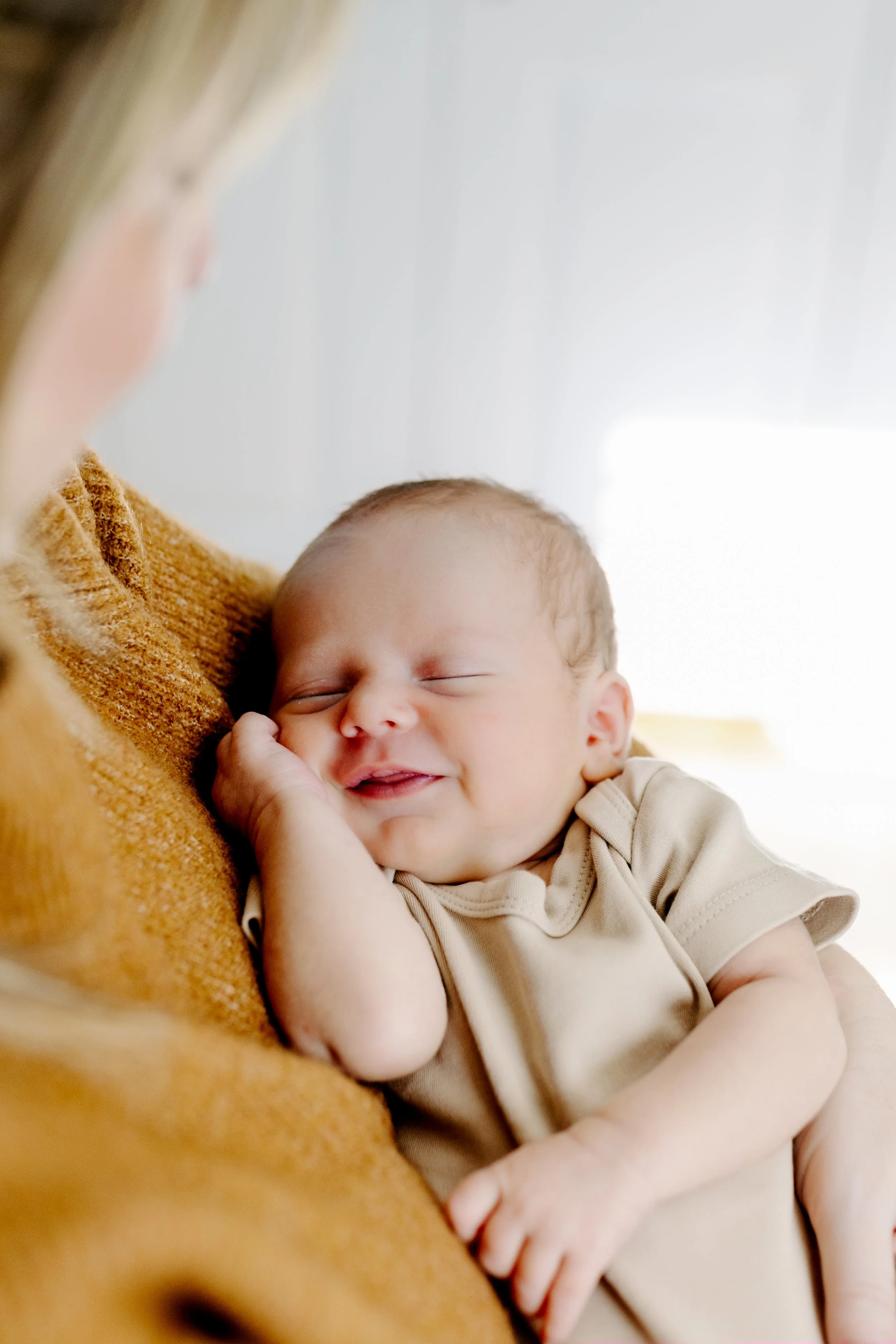Lifestyle at-home newborn photo session with sleeping baby in mom’s arms