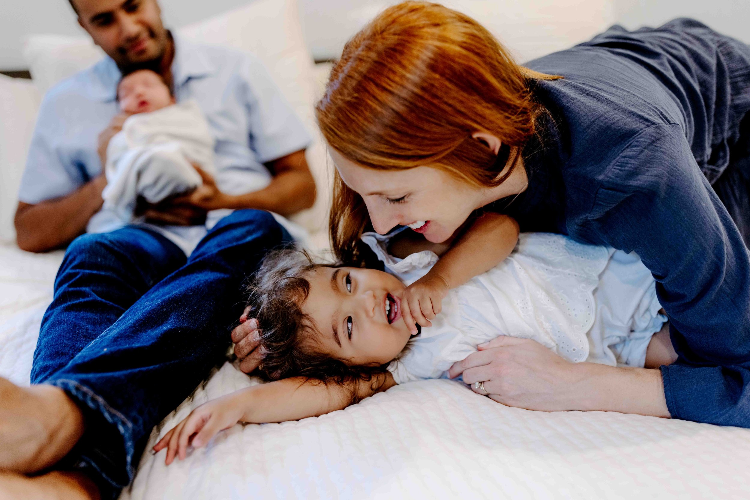 Parents and toddler welcoming newborn during in home newborn photography