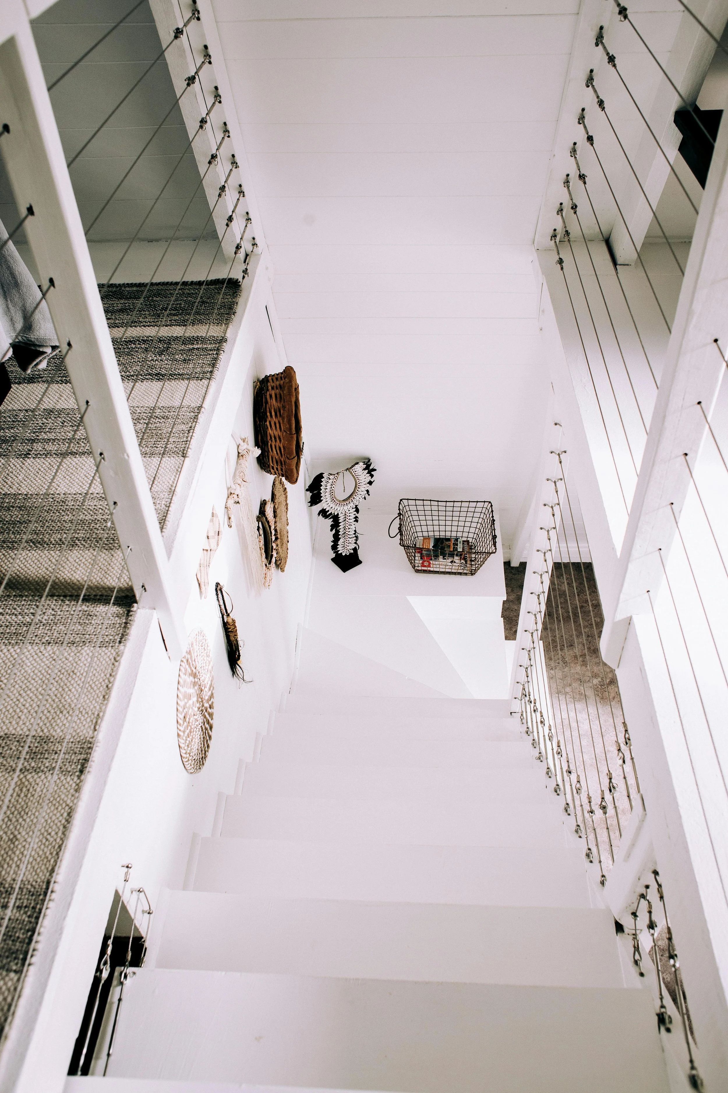Bright, clutter-free staircase with a basket beside the stairs—illustrating a simple, intentional system for keeping steps clear and items moving smoothly between floors.