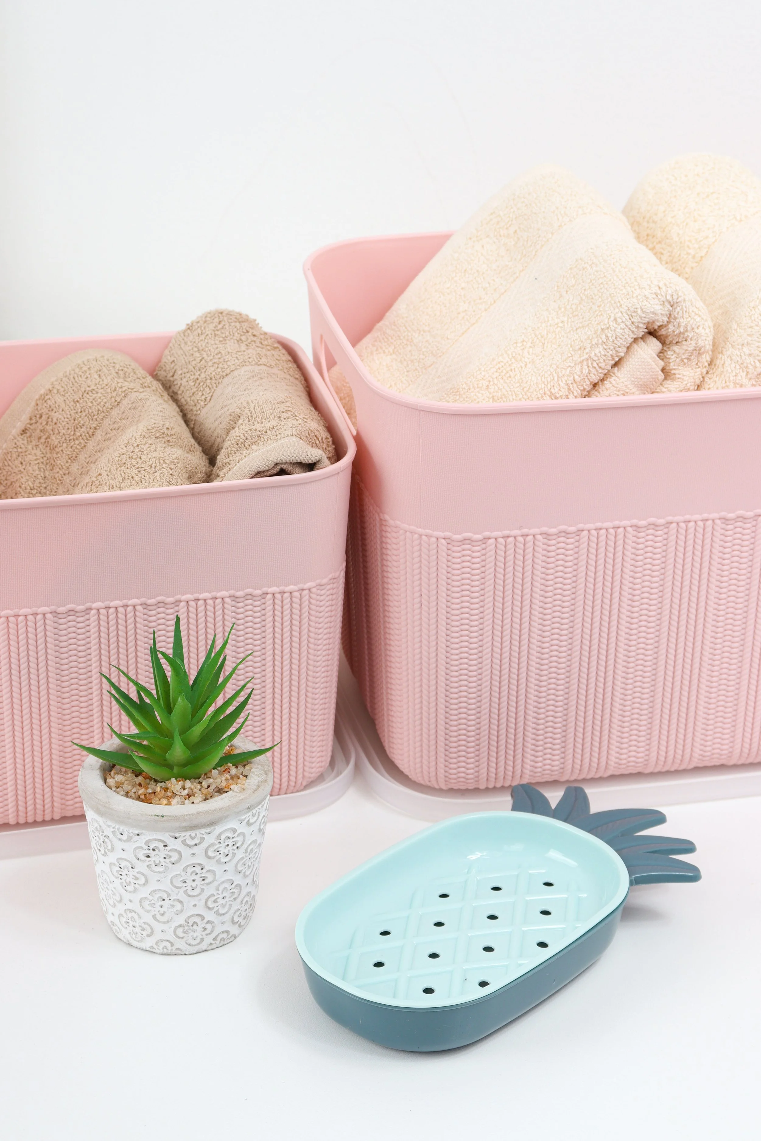 Neatly folded towels stored in matching pink bins, symbolizing how thoughtful preparation and the right organizing systems help turn readiness into lasting order.
