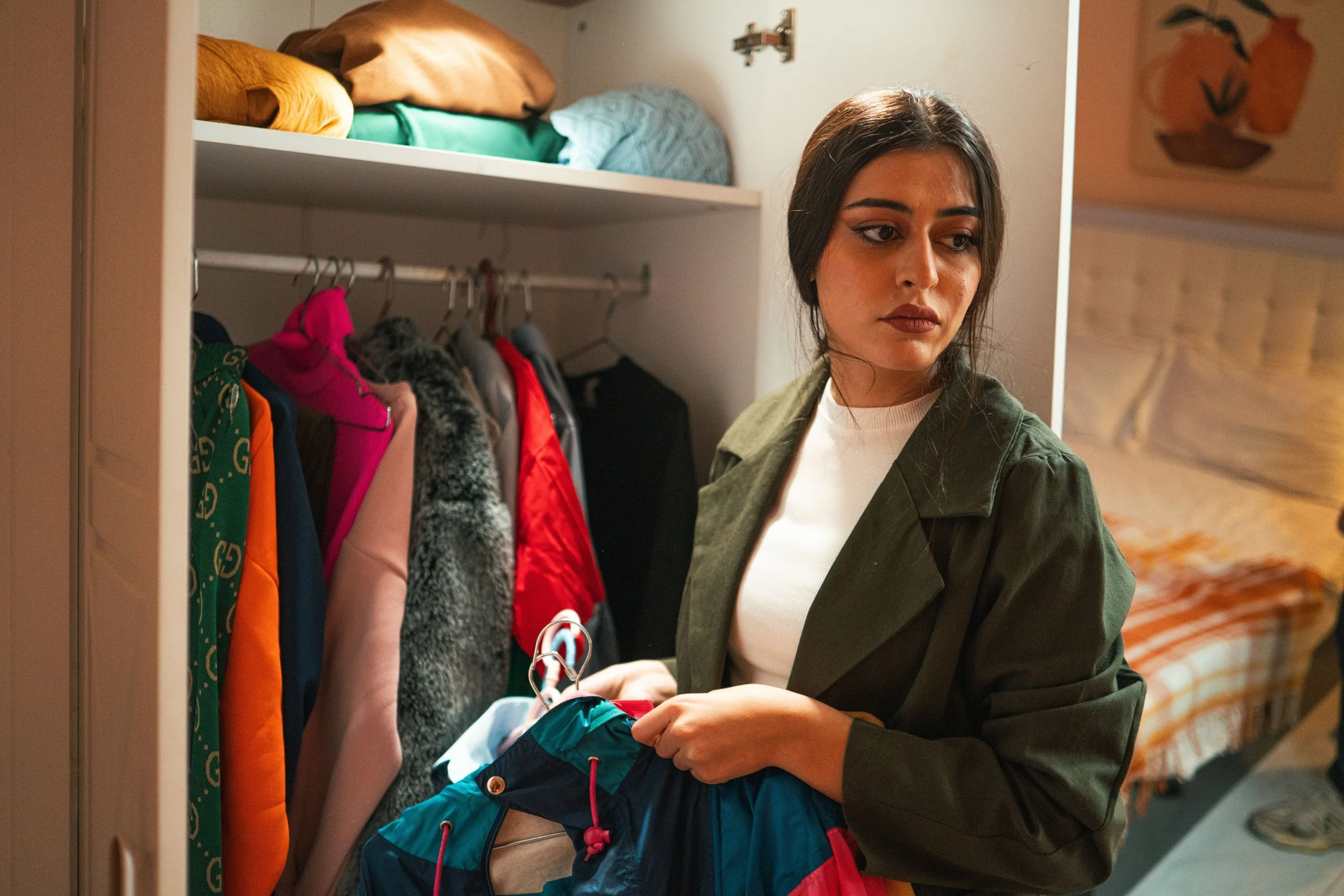 Woman sorting clothes in her closet during a home organizing session.