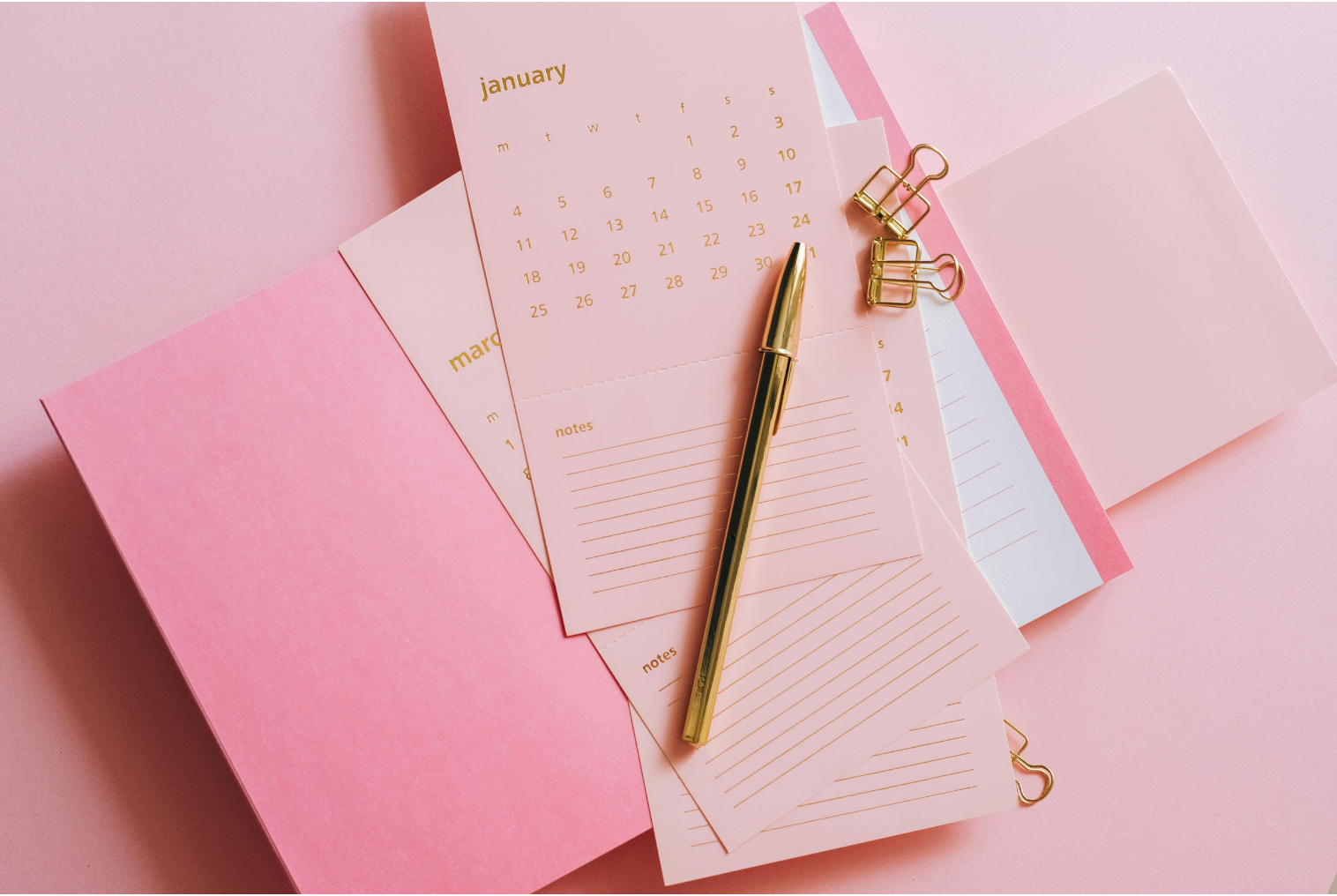 Soft pink calendar pages and planner accessories symbolizing the importance of decluttering your schedule to create more peace, clarity, and space to begin organizing your life.