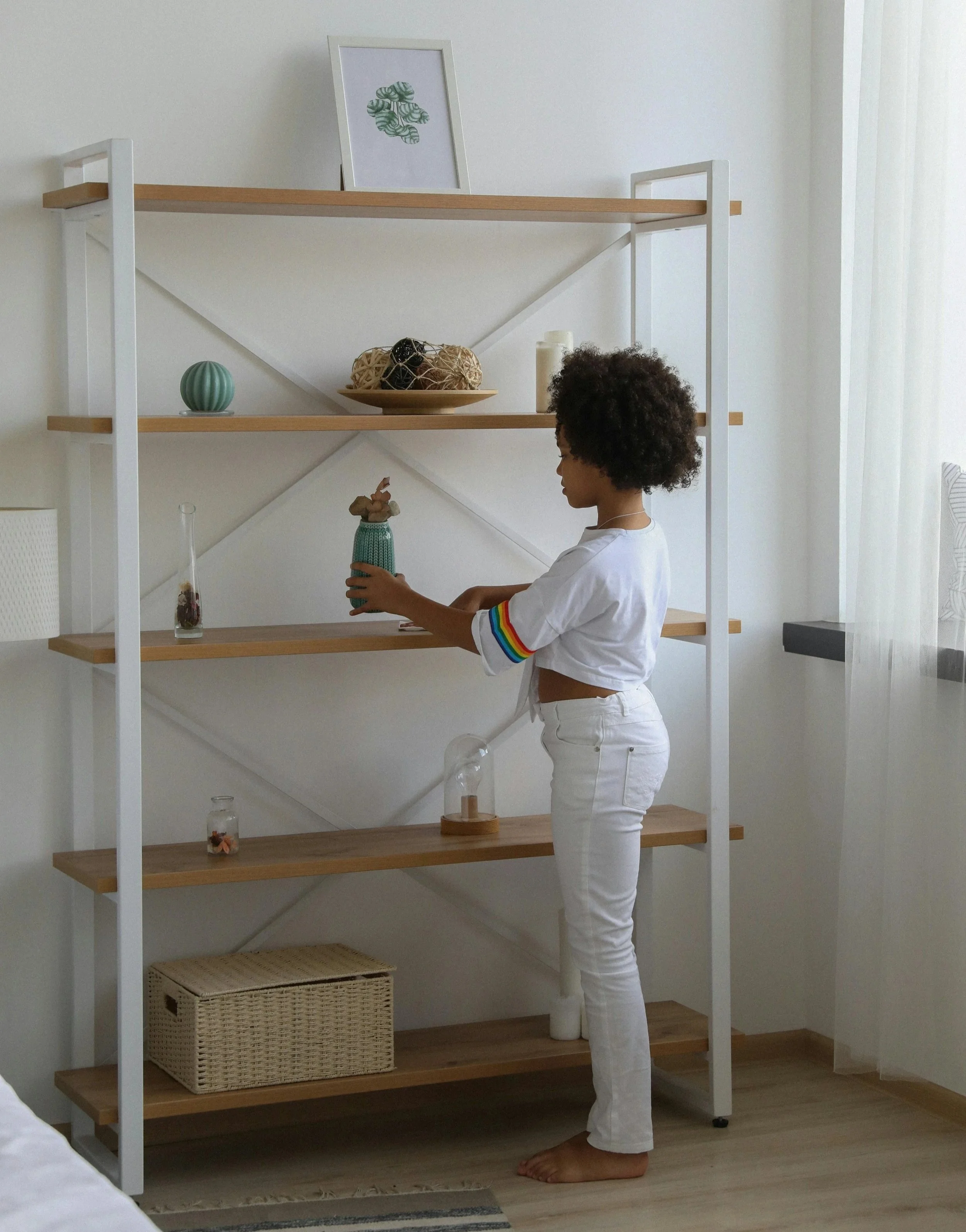 Child thoughtfully placing an item on a shelf, learning to choose what to keep and gently let go.
