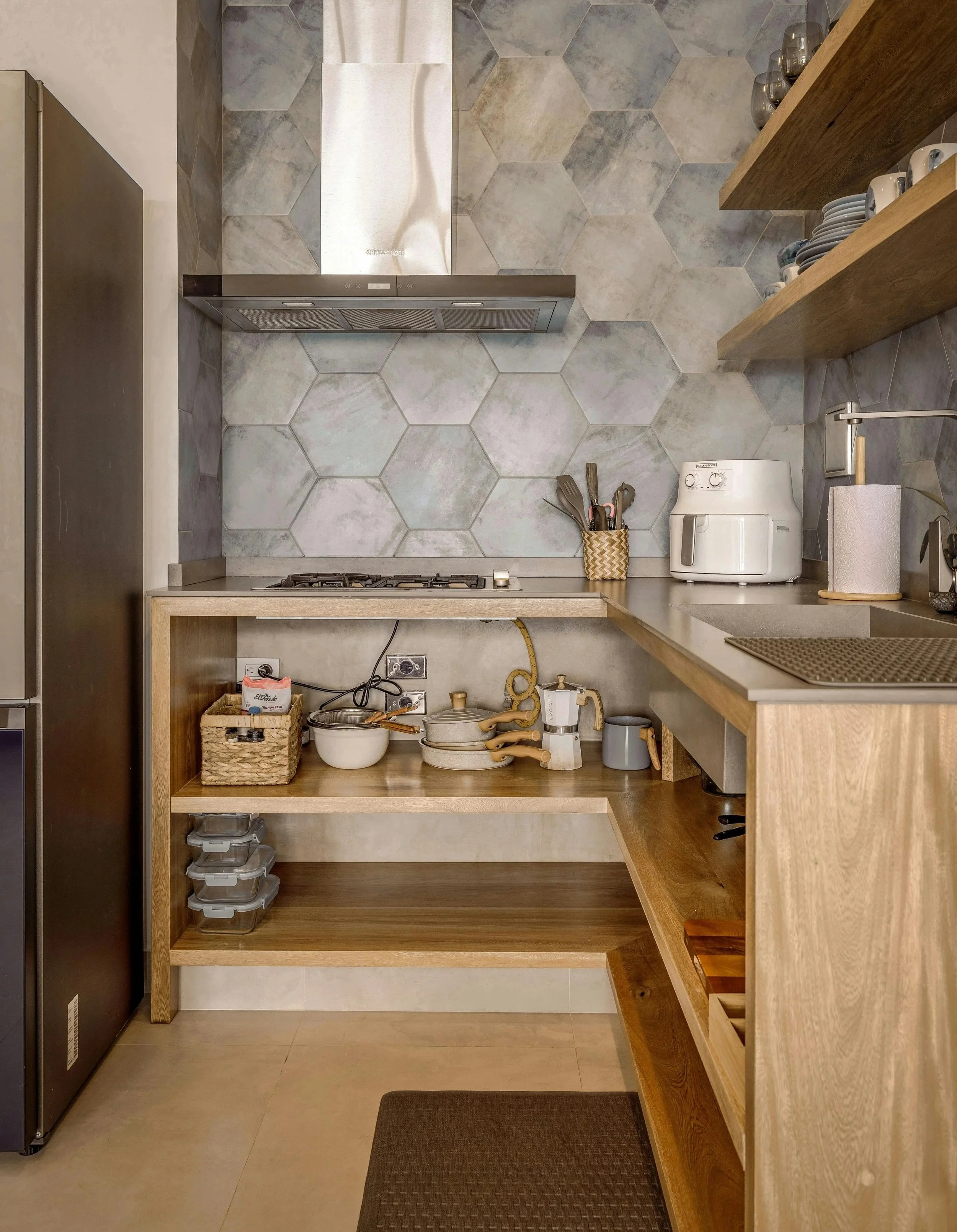 Organized kitchen with open shelving and designated storage areas, showing how giving items a proper home creates calm, functional space.