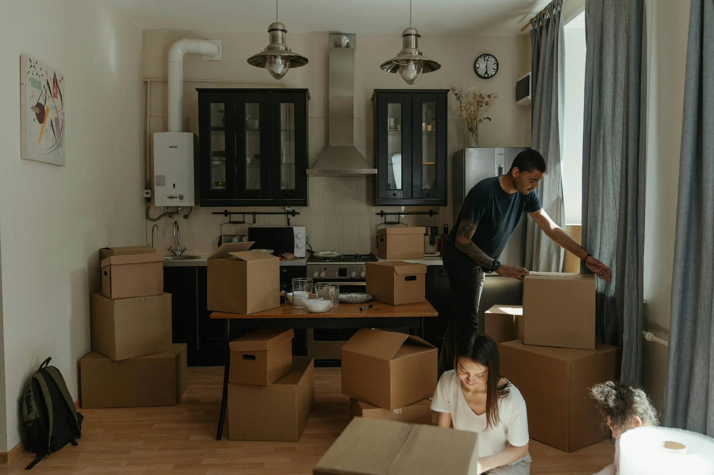 Family unpacking moving boxes in a new home while creating a calmer, more intentional space.Family unpacking moving boxes in a new home while creating a calmer, more intentional space.