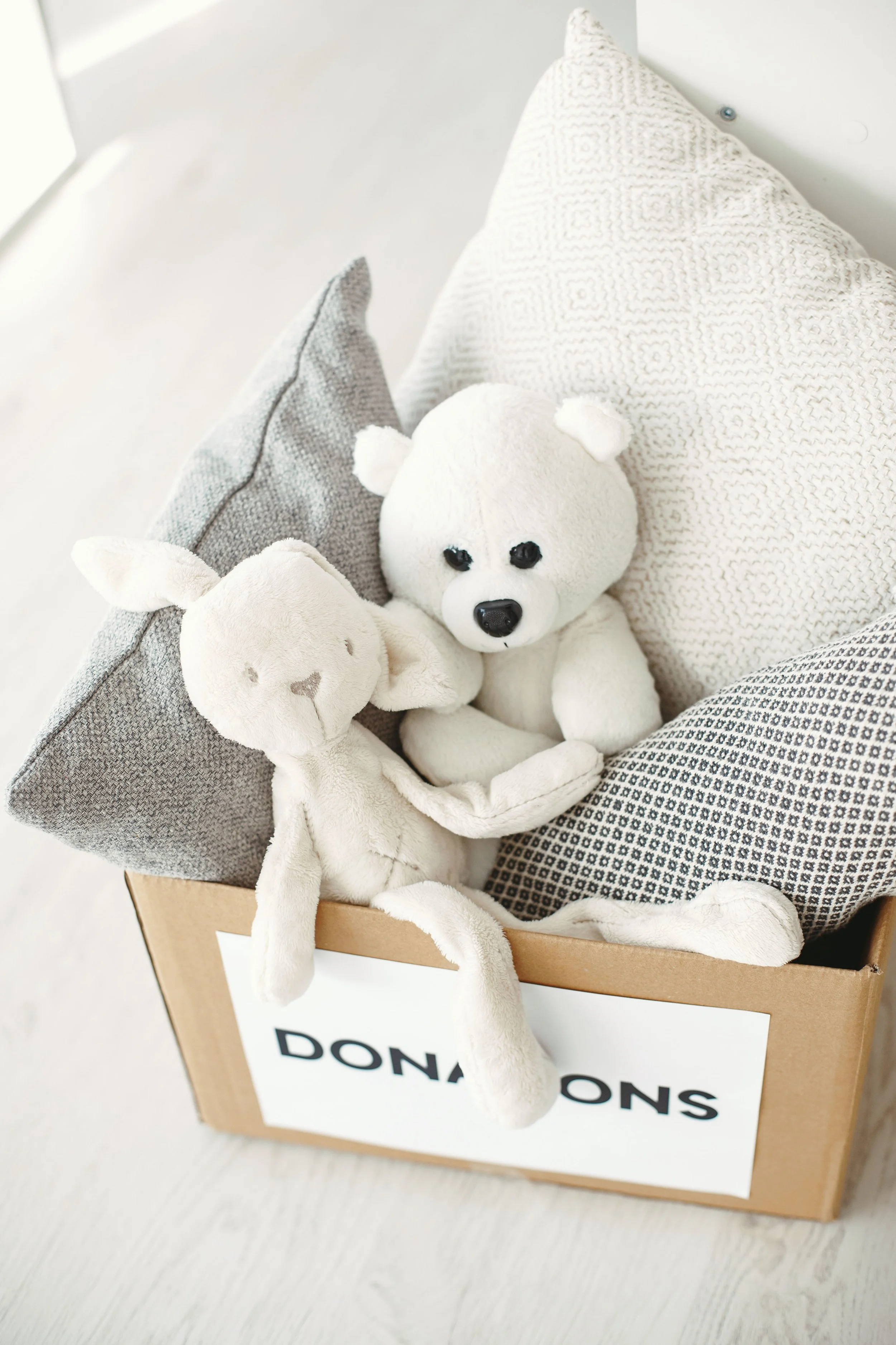 Donation box filled with pillows and plush toys, reminding us that letting go through convenient donations helps reduce clutter and create a more peaceful, organized home.
