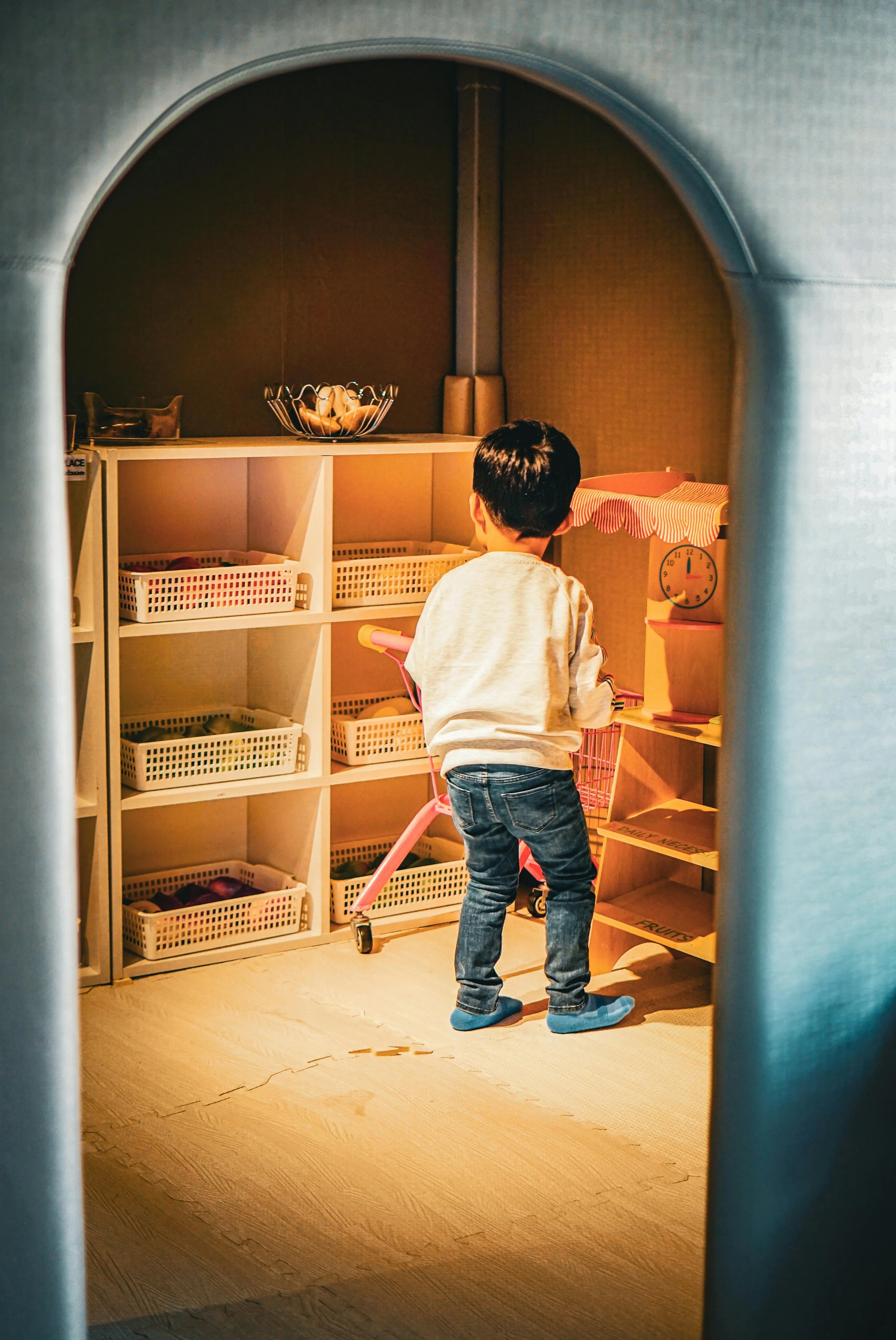 Child calmly sorting toys into baskets, thoughtfully deciding what to keep, donate, or hold onto with care.