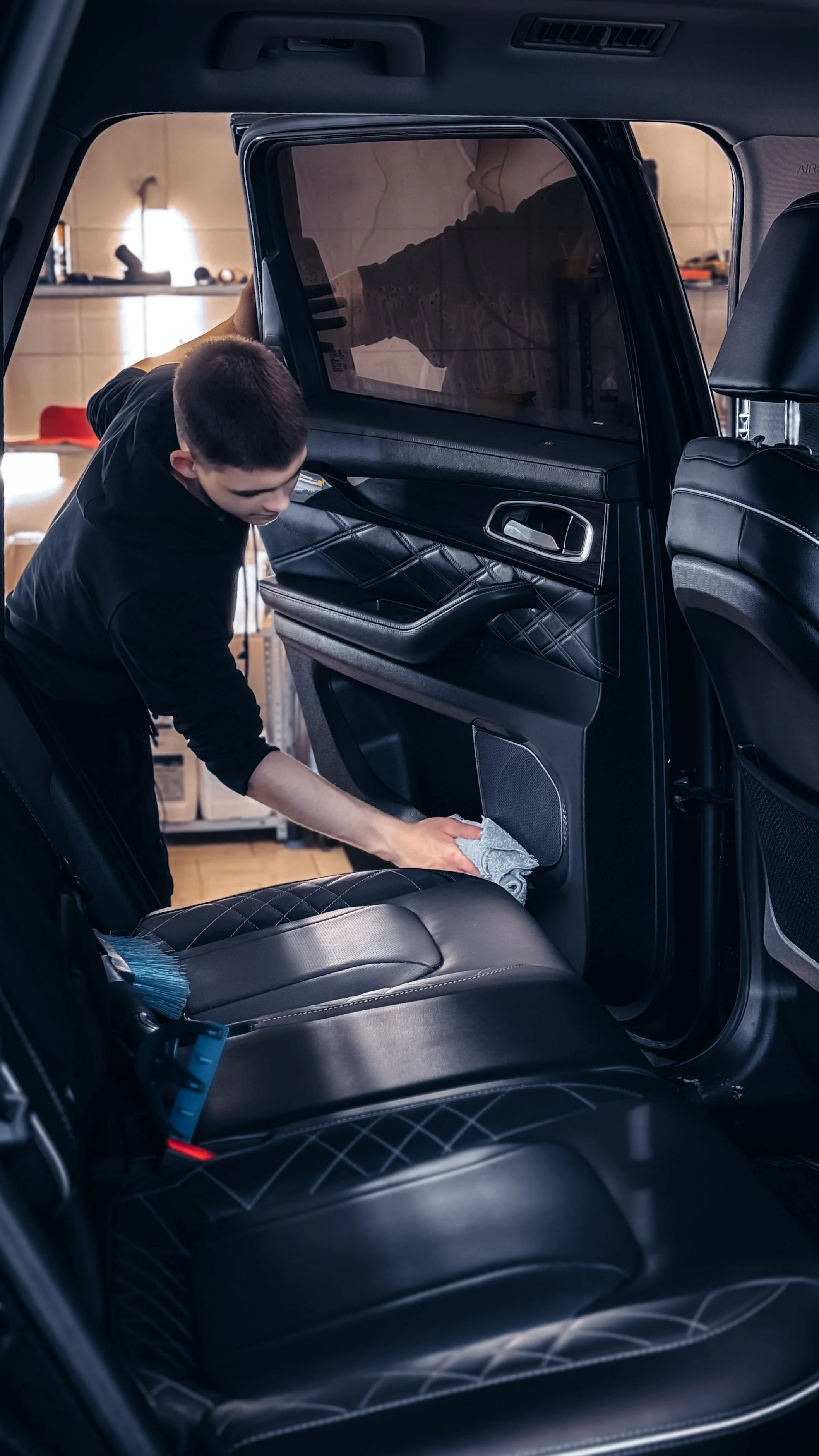 Person wiping down a car interior during a weekly reset routine, illustrating how simple organizing habits help maintain order, reduce overwhelm, and create a calmer mind.
