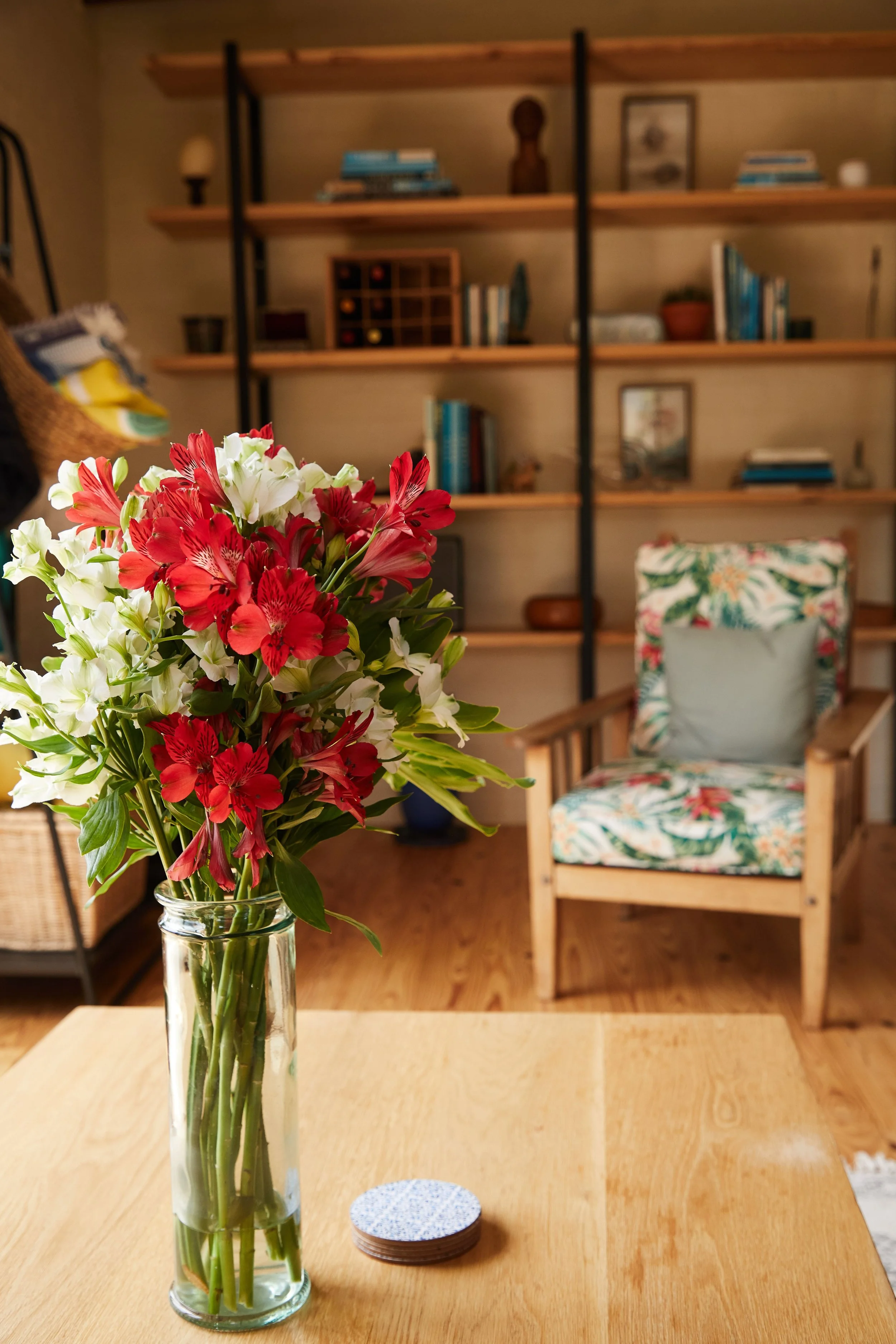 Fresh flowers on a coffee table in a beautifully organized, welcoming living room that reflects the peace and joy of a house becoming a home.