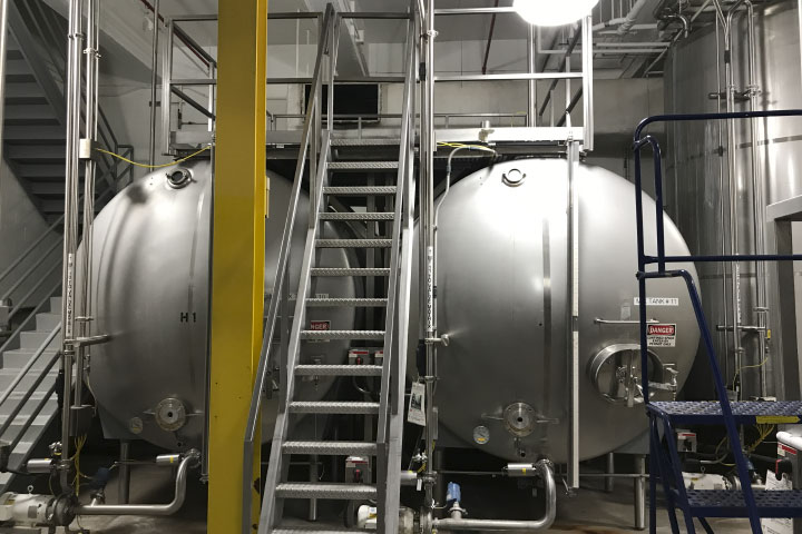  After: Yale Mechanical designed and installed a stainless-steel platform to sit above the tanks and a staircase to connect it to ground level. 