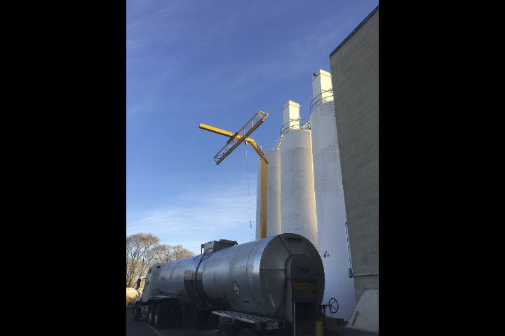  Towering above H.B. Fuller's lot, the standing arm protects workers by preventing injury due to falls from the top of tanker trucks parked in front of it. 