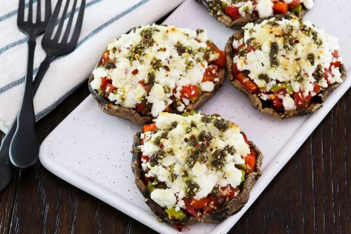 Photo of roasted portobello pepper caps with goat cheese, tomatoes and spices on a plate