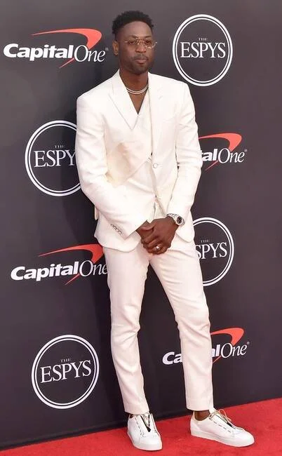 Dwyane Wade in this pure white Louis Vuitton suit with sash, paired with Jason of Beverly Hills chain and Fabrice Tardieu sneakers