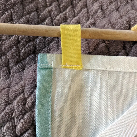 A little scrap of bias tape makes a perfect tab.  You can also use fabric scraps.  You do not need a lot of fabric to make these tabs.