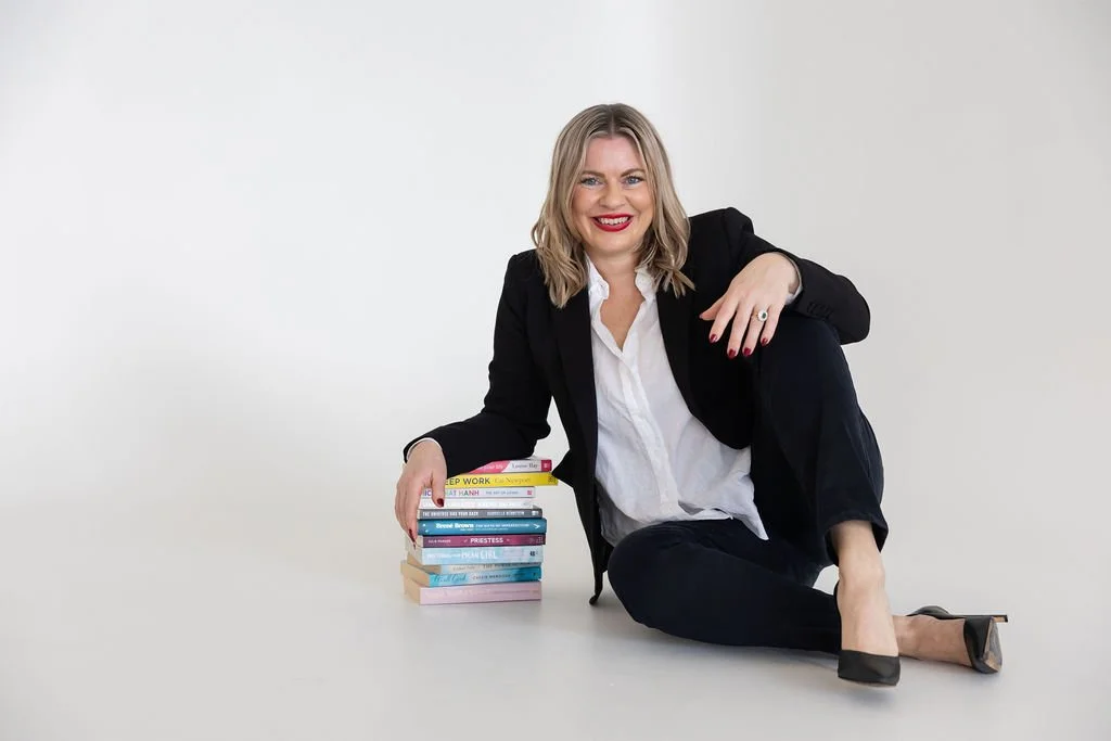 Portrait of Bec Sands, seated on the floor with her favourite books