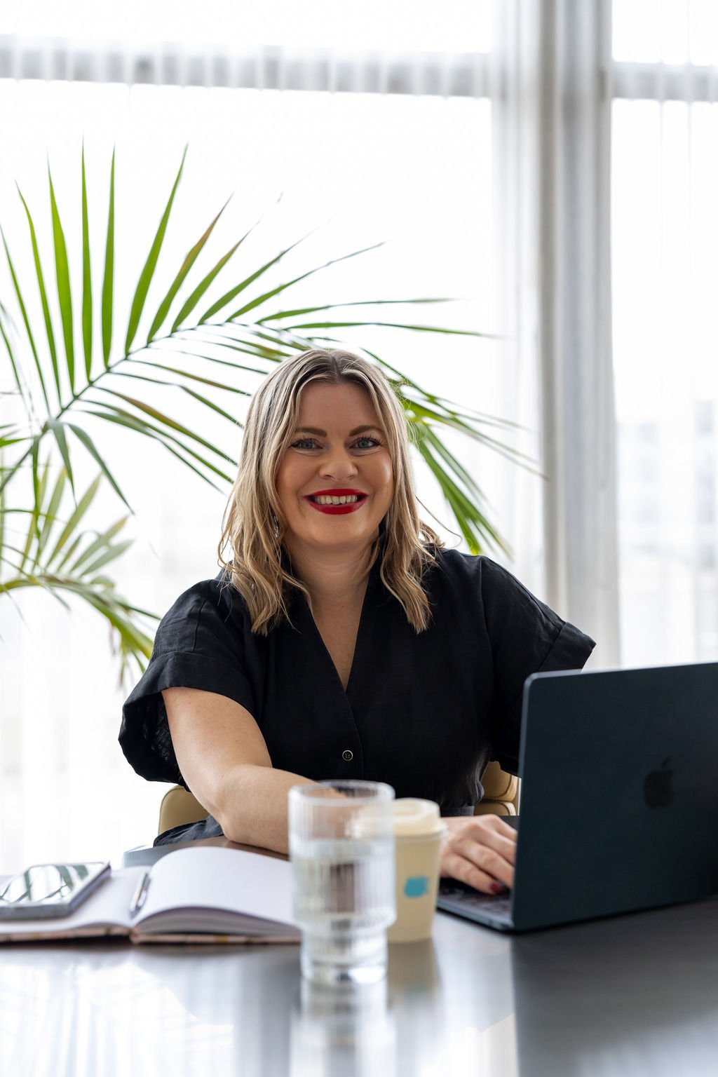 Portrait of Bec Sands working at her desk