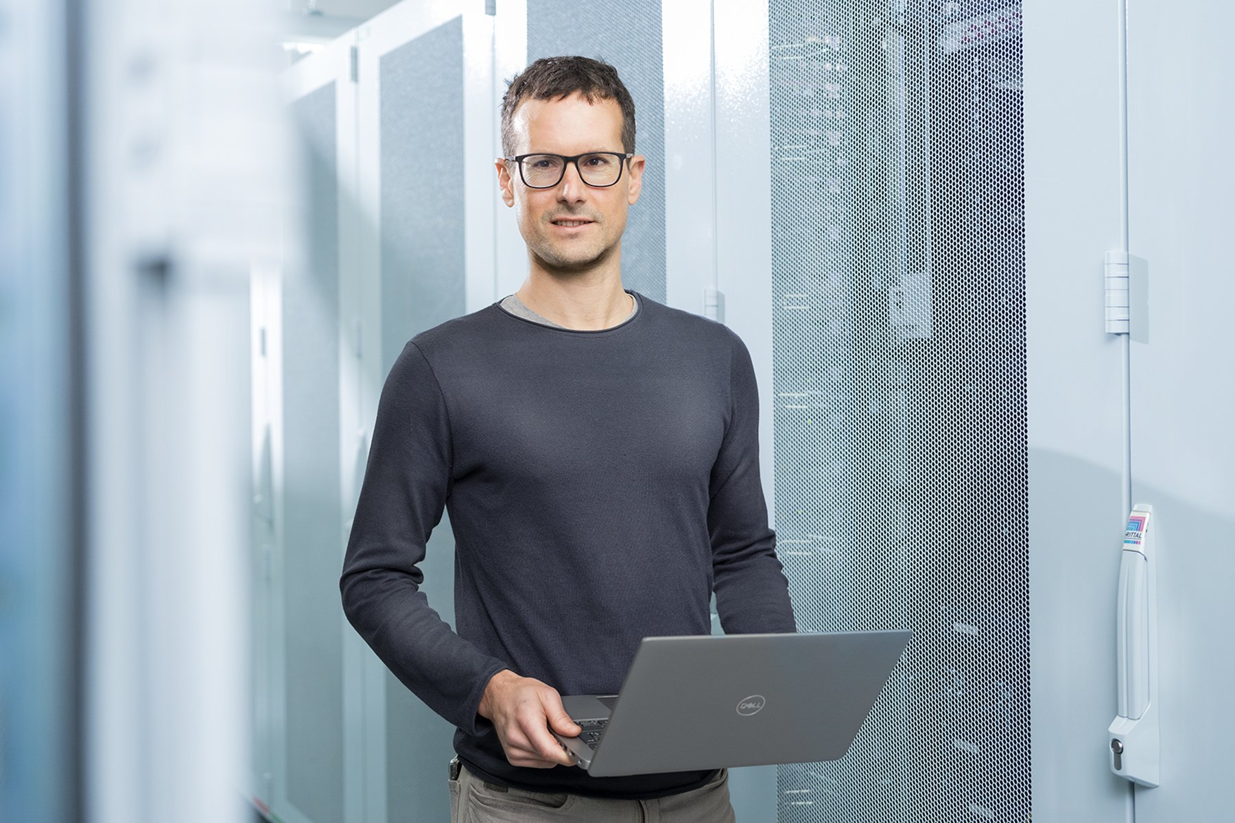 Businessportrait eines Unternehmers mit Laptop und Brille im modernen Gebäude – Businessfotografie Stuttgart