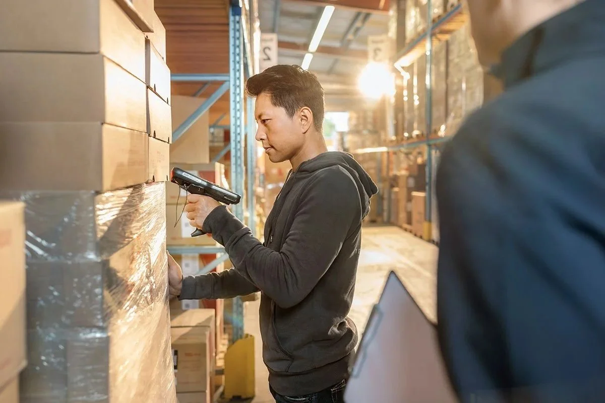 Mitarbeiter in Logistik beim Scannen von Artikel