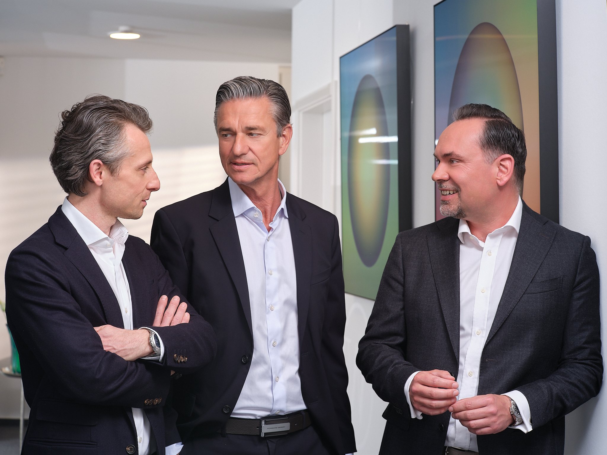 Drei Manager unterhalten sich im Flur ihres Büros