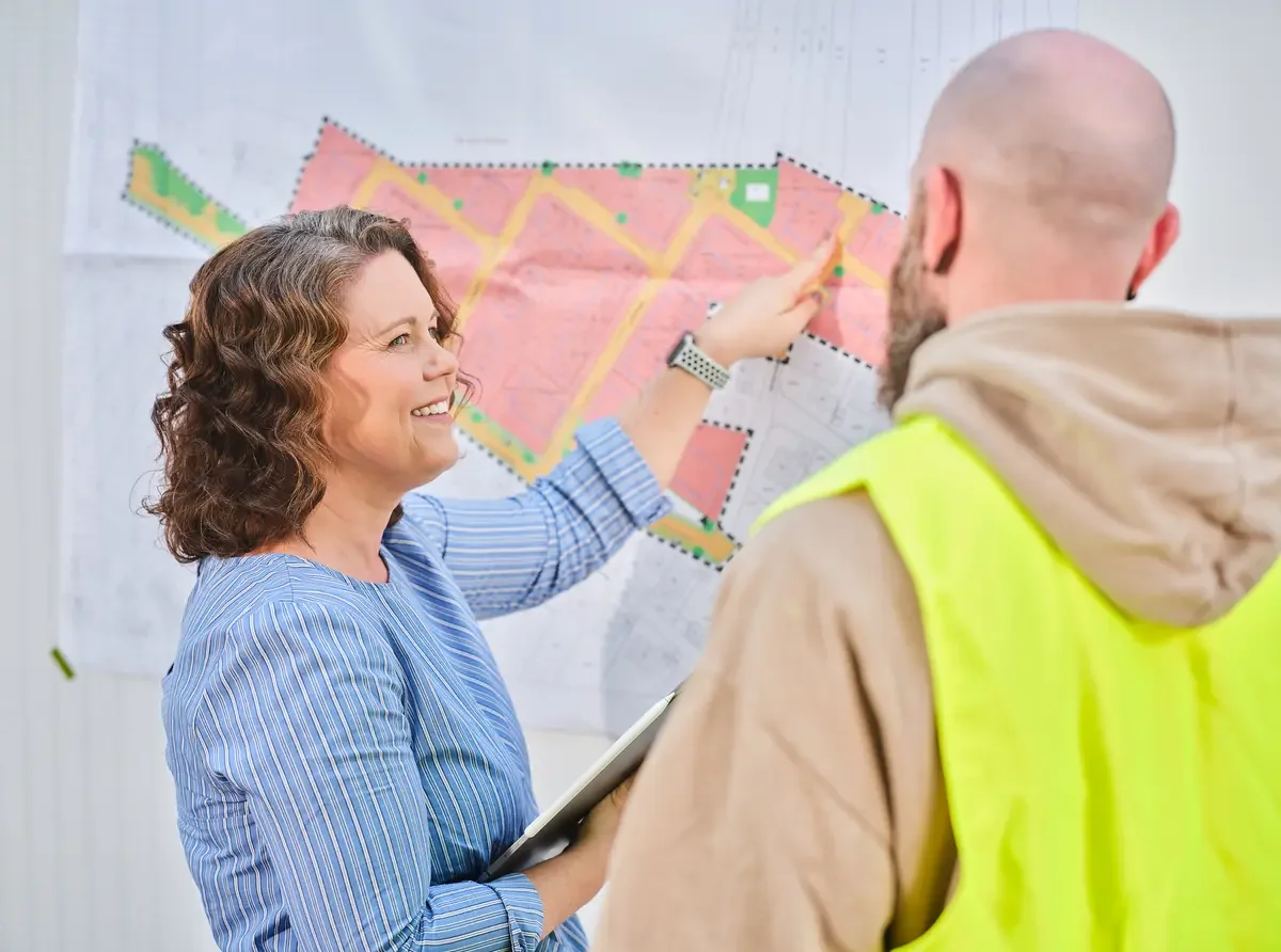 Stadtplanerin zeigt auf Bebauungsplan