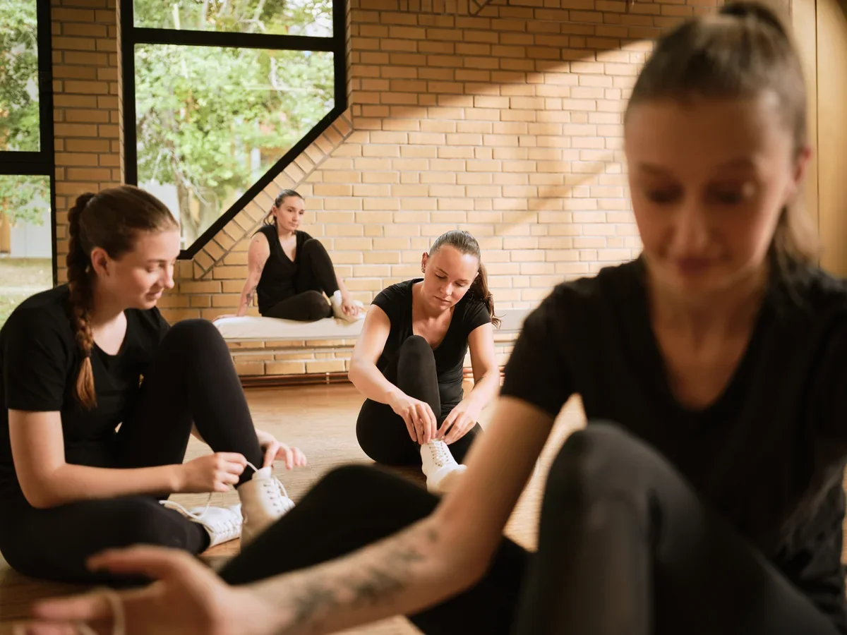 Tänzerin schnürt Schuh beim Training