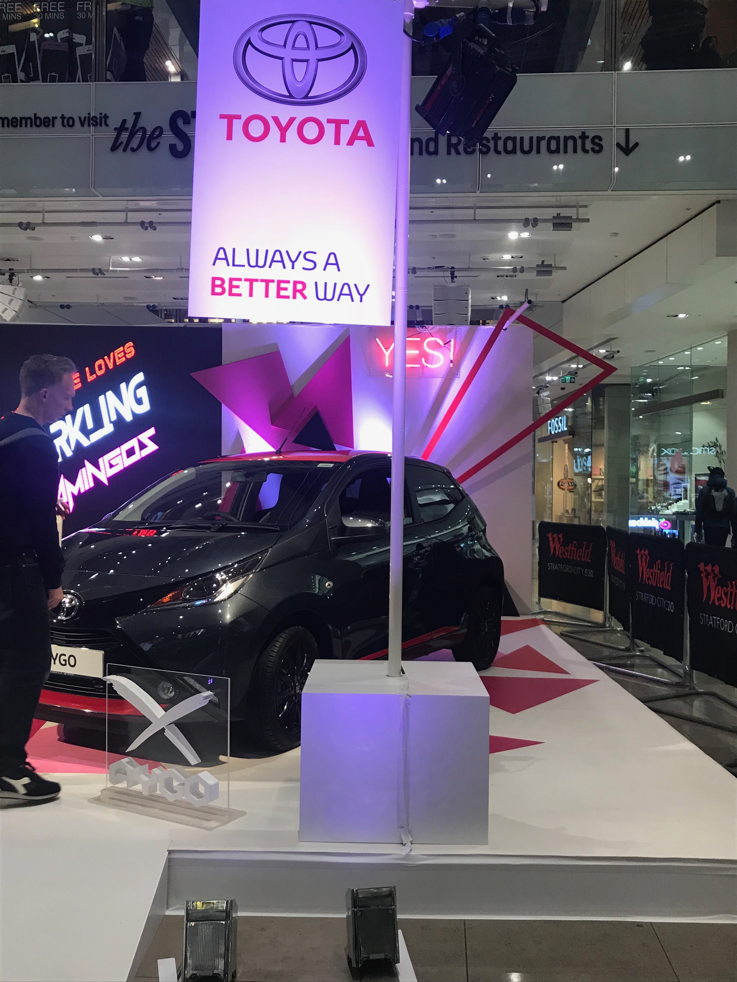 Toyota car with pink triangles and white lights.