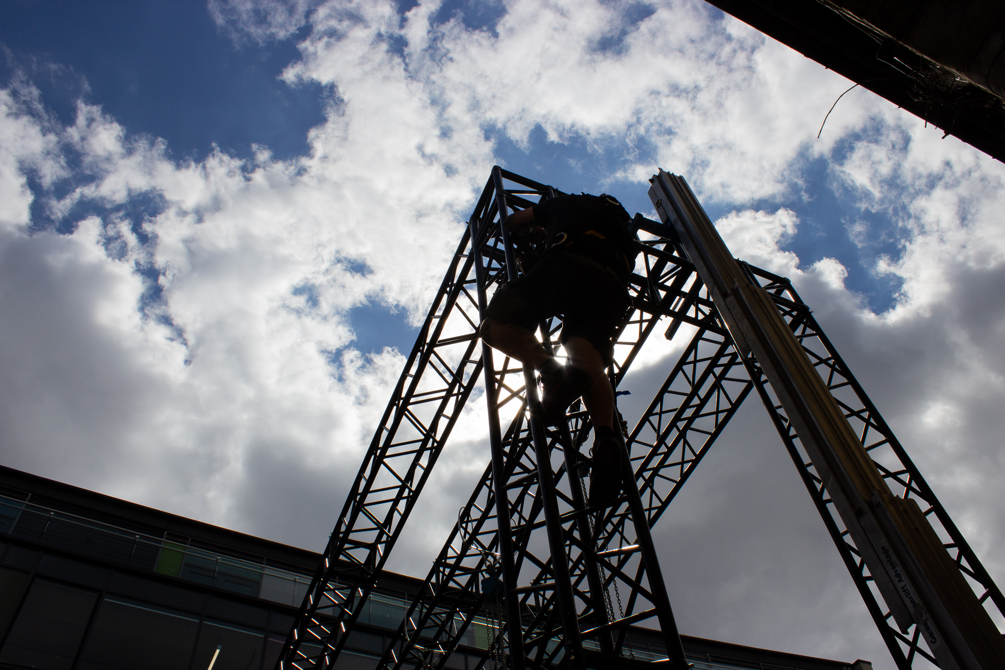 man climbing truss