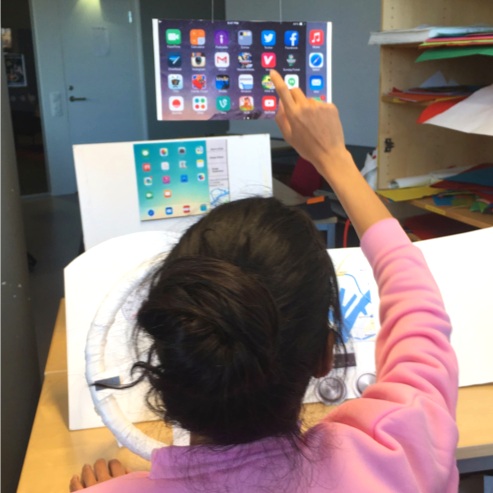 User Testing with the Paper Prototype assessed the following ideas:o 1. Phone mirroring on the back seat - the user was asked to assist the driver with a route change and change the volume using our interfaceo 2. Front seat screen sun visor - The us…