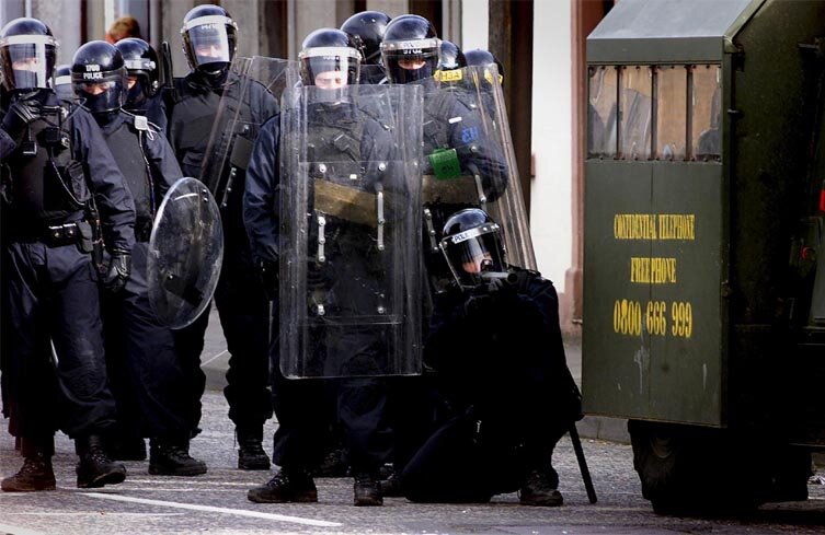 Garda holds a riot shield as protestors are stopped in a street in Dublin,  after Britain's Queen Elizabeth II arrived in the country for a four day  state visit Stock Photo 