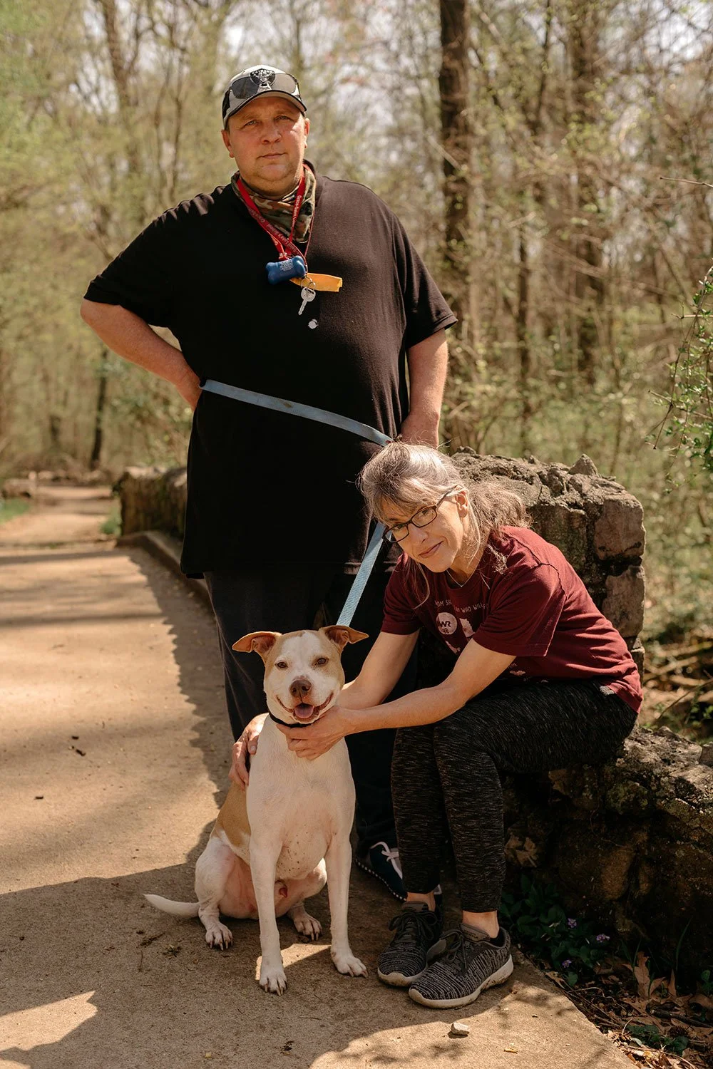 A man and woman with their dog walking in Overton Park in Memphis, Tennessee