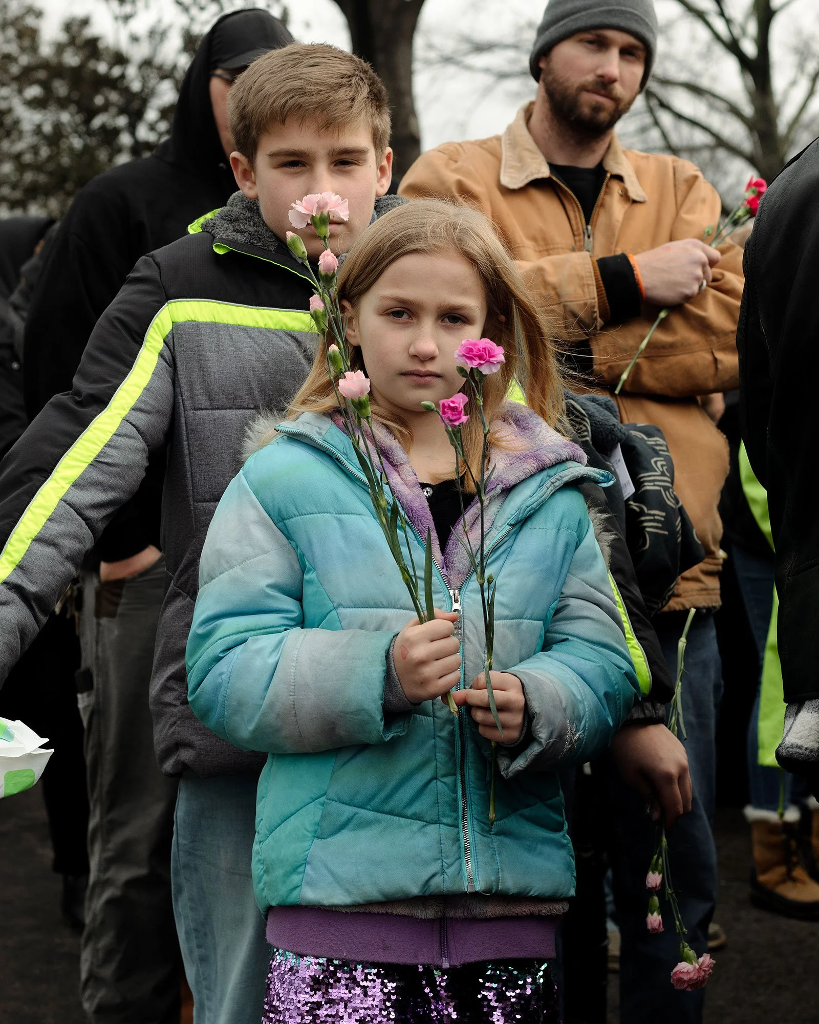 A child stands in line with fake roses to pay tribute to Lisa Marie at her funeral at Graceland in Memphis, Tennessee