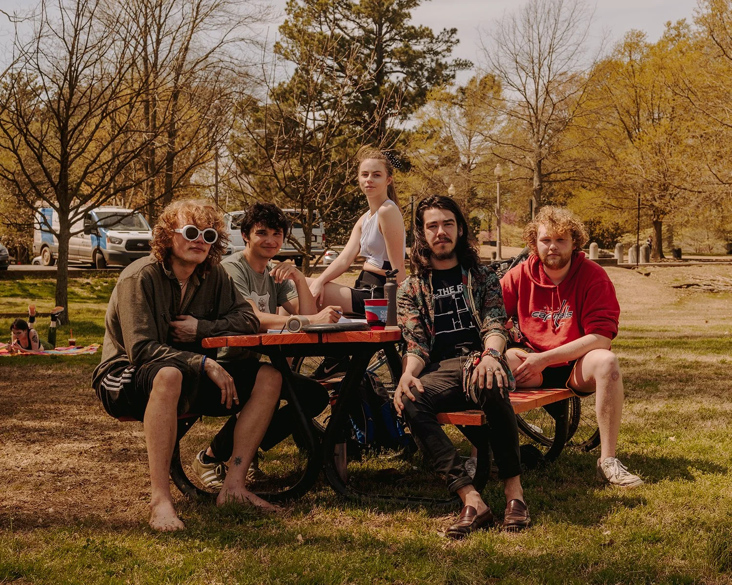 A group of young people sit at a picnic table at Overton Park in Memphis, Tennessee