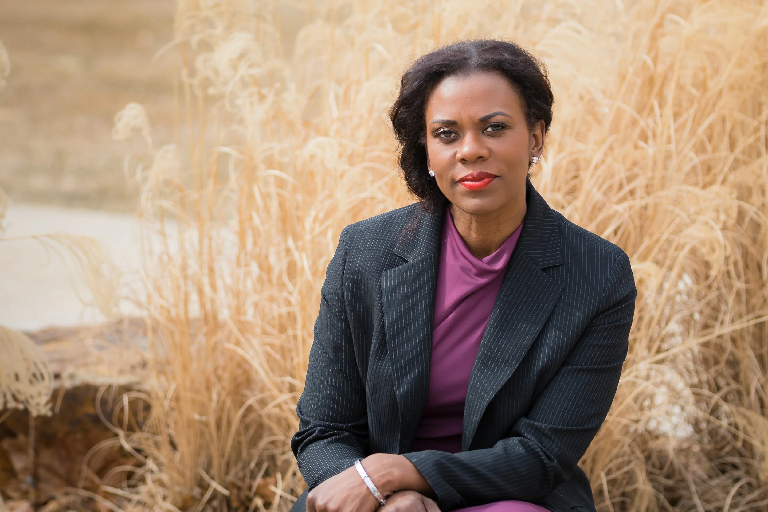 Branding Photo of female health practitioner sitting in front of fall grass